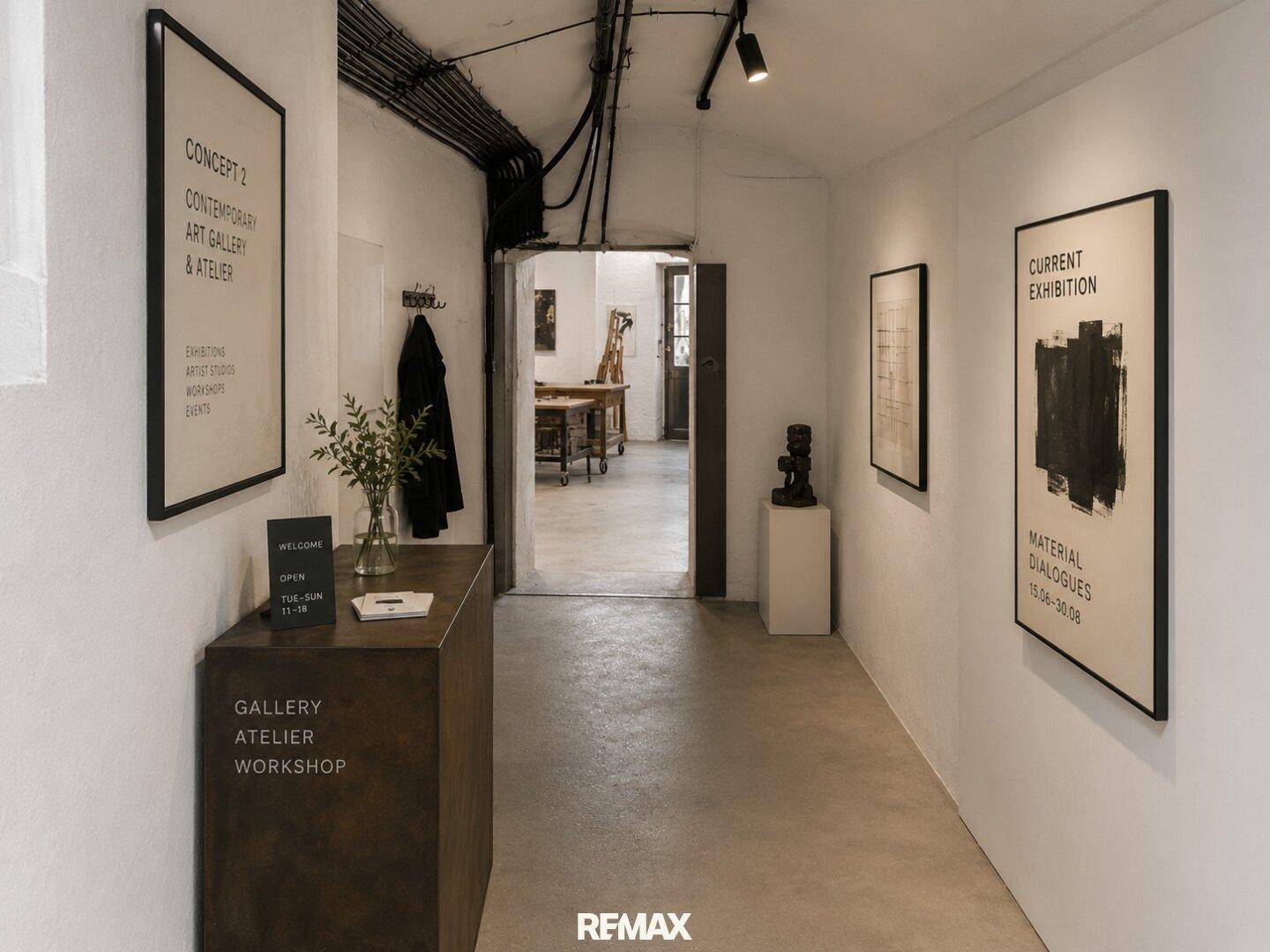 Eingangsbereich oder Flur einer Galerie mit Empfangstresen, Kunstwerken und Zugang zu weiteren Räumen.
