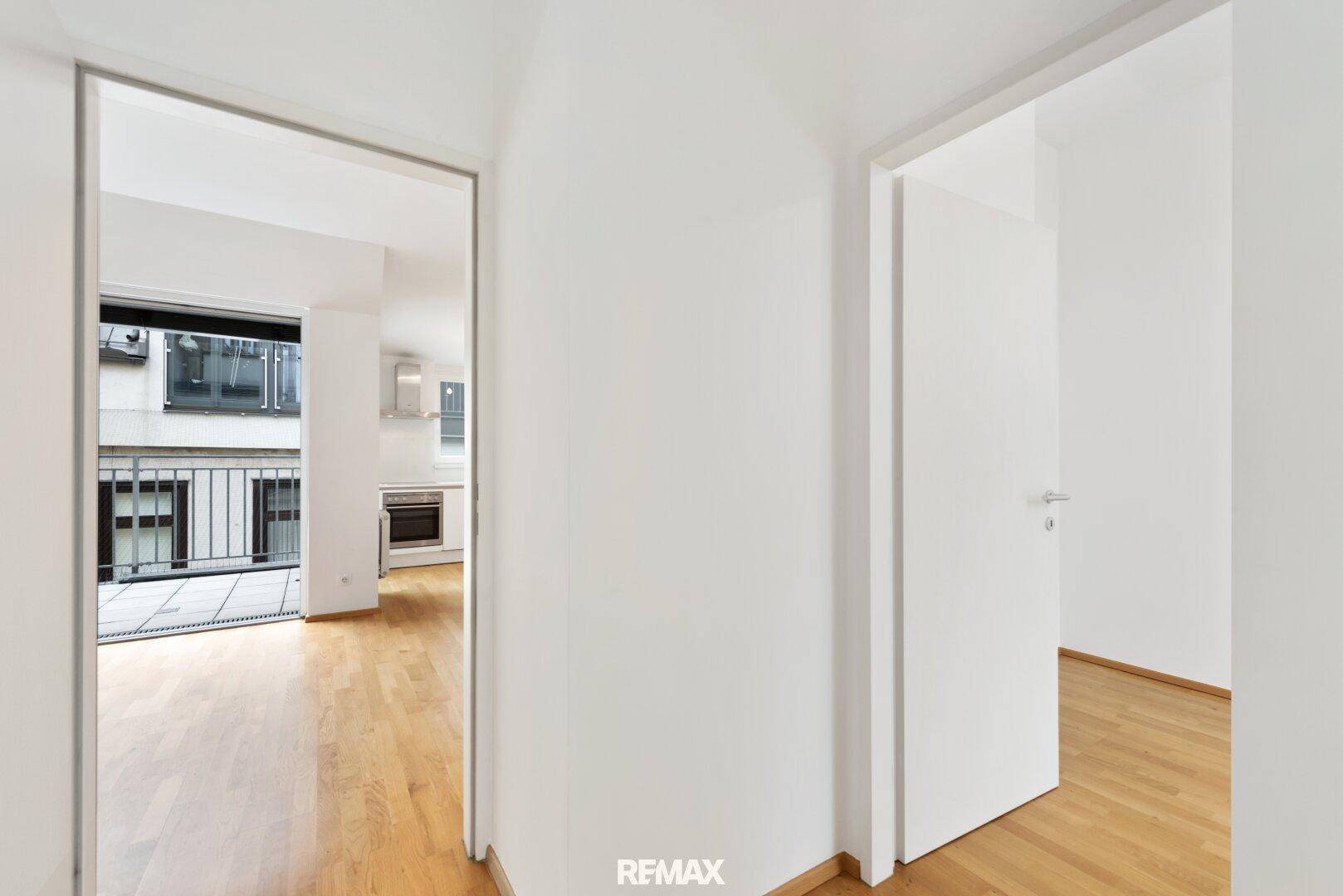 Flur mit Blick in den offenen Wohnbereich und Zugang zu einem weiteren Zimmer.