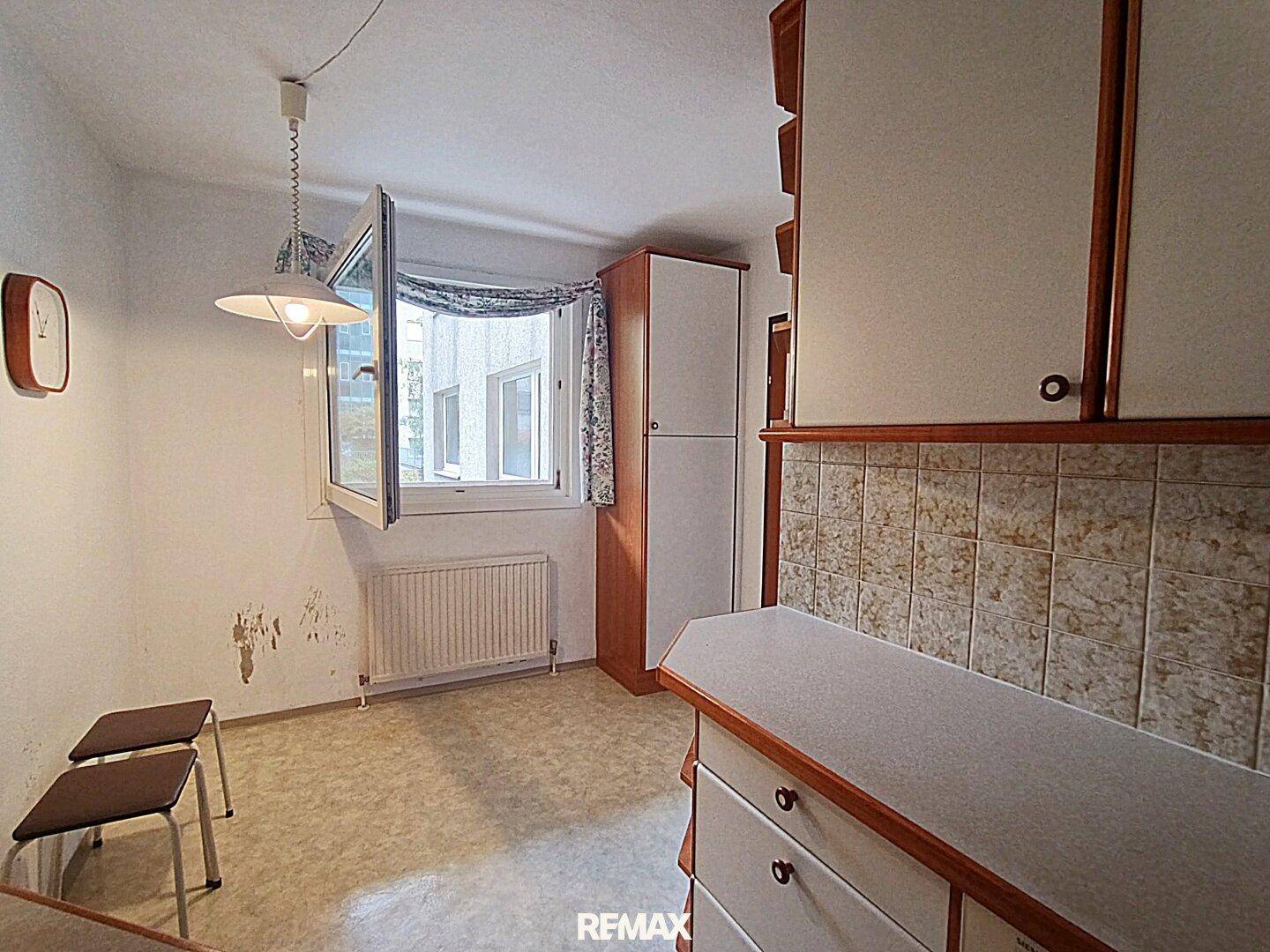 Helle Küche mit Fenster und Platz für einen kleinen Esstisch, ideal für Frühstück.
