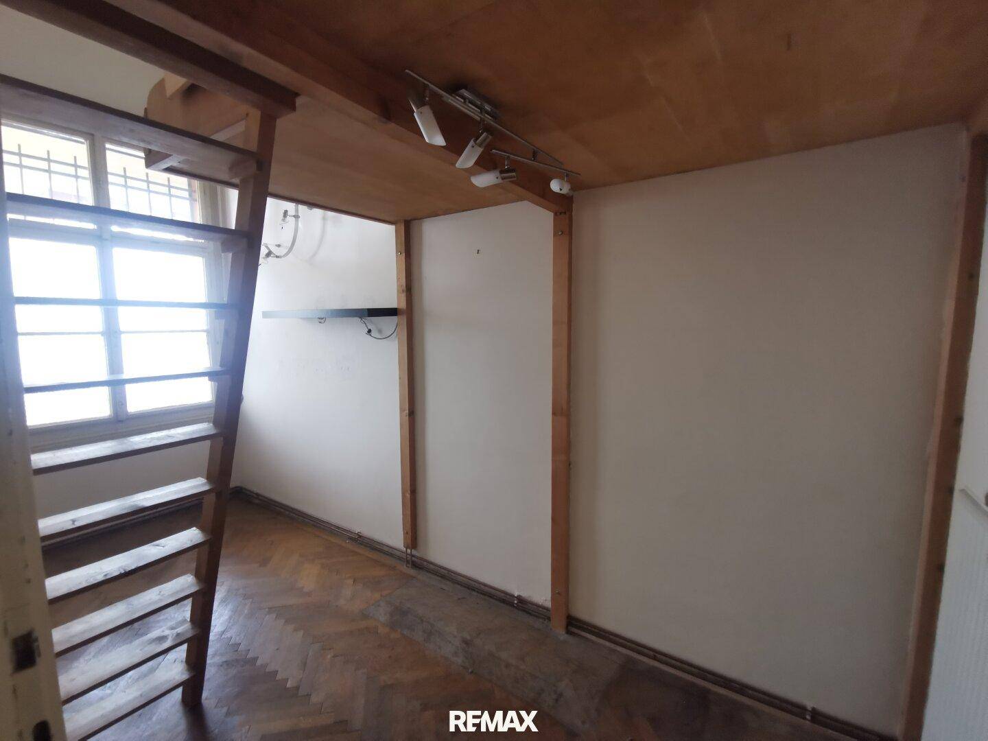 Zimmer mit Holzdecke und Hochbettzugang, bietet eine einzigartige Raumnutzung und gemütliche Atmosphäre.