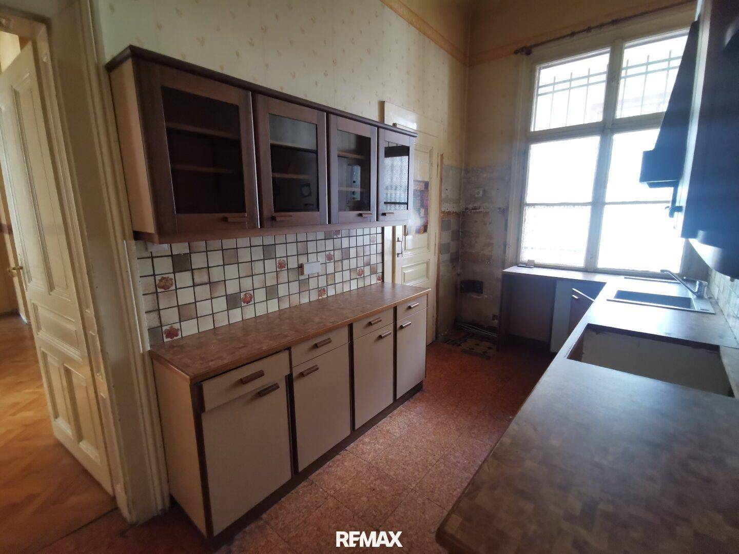 Küche im traditionellen Stil mit Fliesenboden, Einbauschränken und großem Fenster.