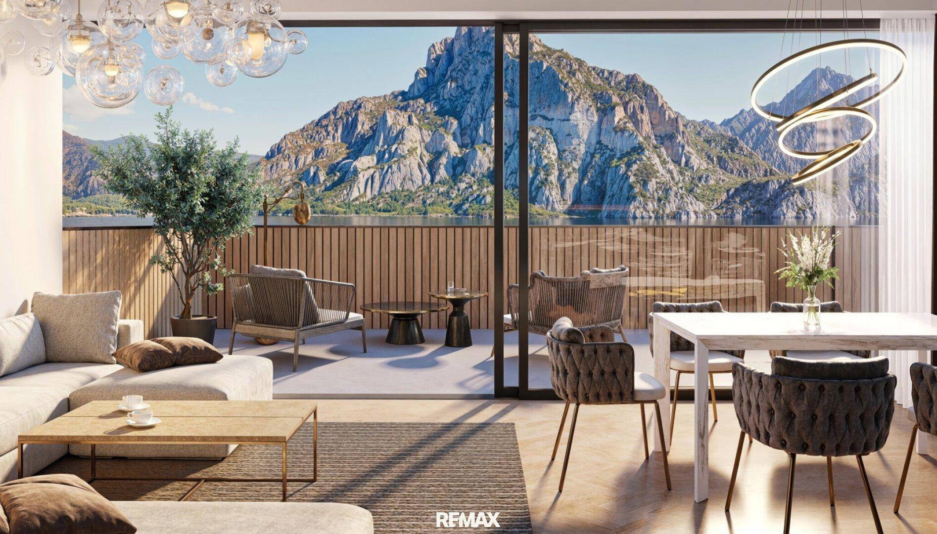 Heller Wohn-Essbereich mit Zugang zur Terrasse und beeindruckendem Blick auf See und Bergpanorama.