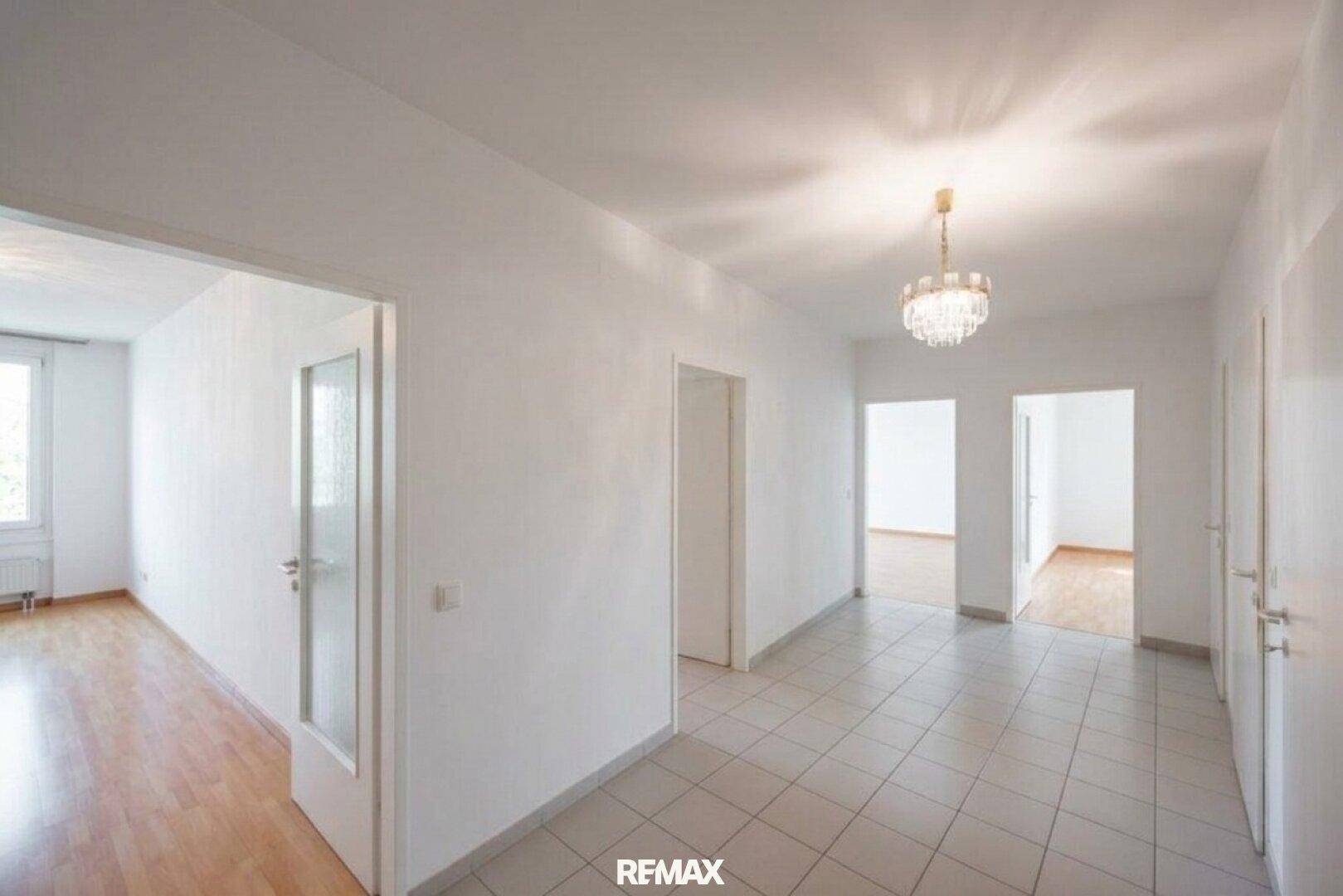 Heller Flur mit Fliesenboden und mehreren Türen, die zu verschiedenen Räumen der Wohnung führen.