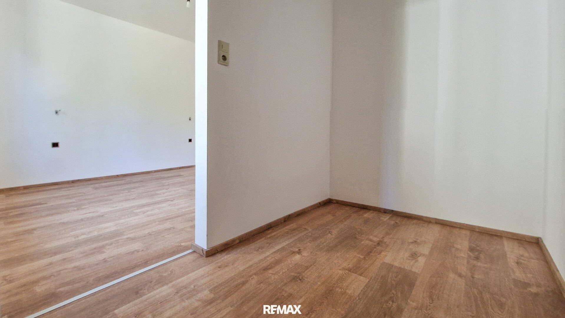 Leerer Raum mit Holzboden und weißen Wänden, bereit für individuelle Gestaltung.
