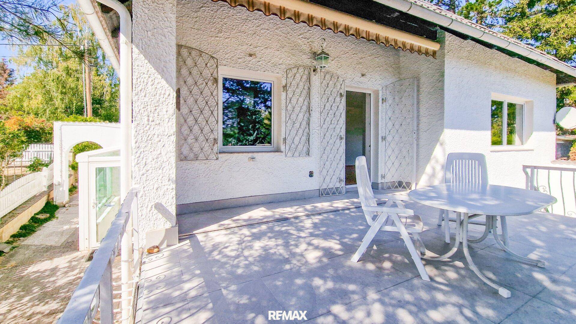 Heller Balkon mit weißem Gartentisch und Stühlen, ideal für entspannte Stunden im Freien.