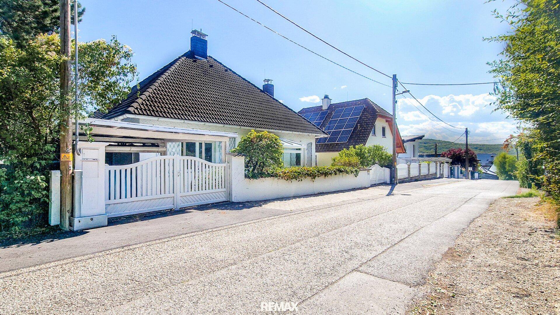 Weitläufige Straßenansicht des Hauses mit gepflegtem Vorgarten und Nachbarhäusern.