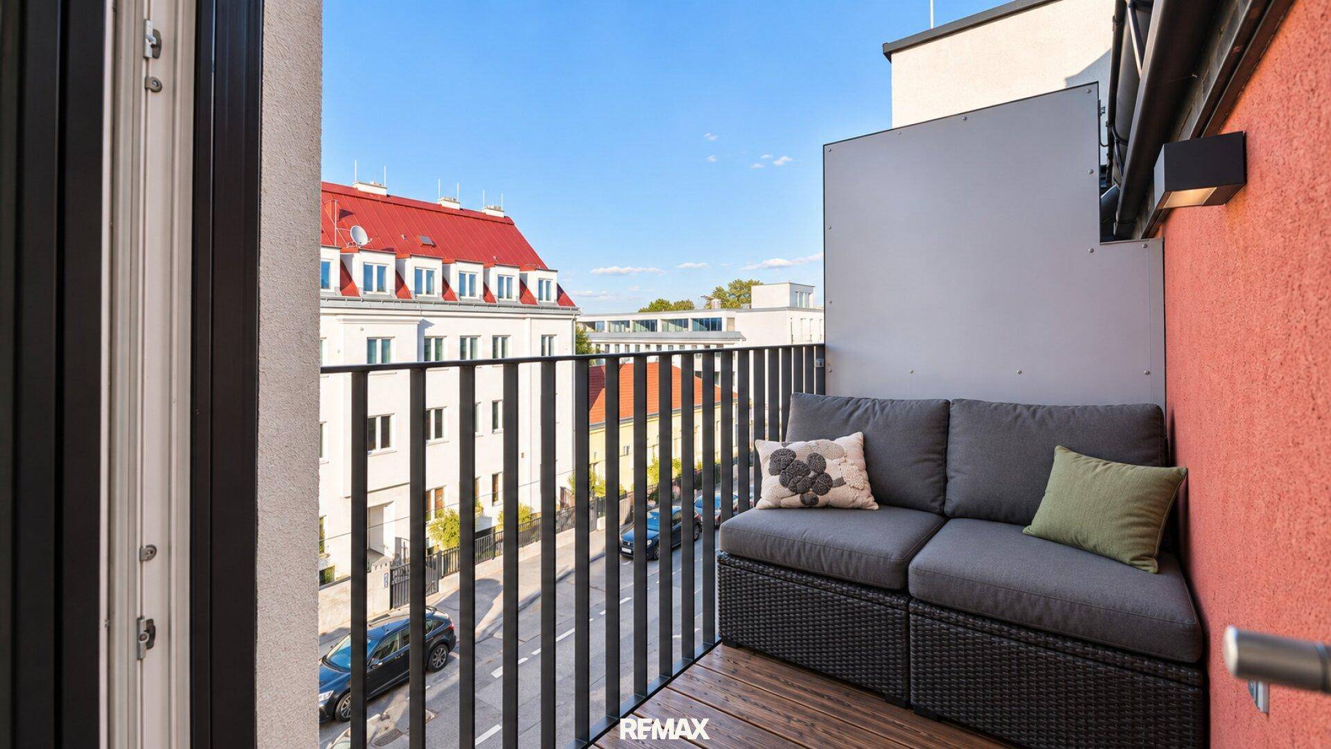 Gemütlicher Balkon mit Sitzgelegenheiten und Blick auf die umliegenden Gebäude.