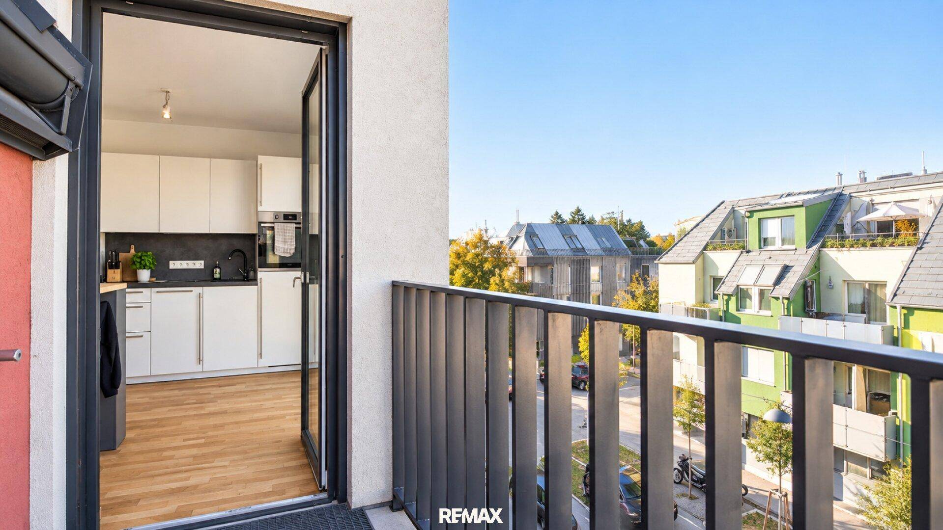 Balkon mit Blick auf die Nachbarschaft und Zugang zur modernen Wohnküche.
