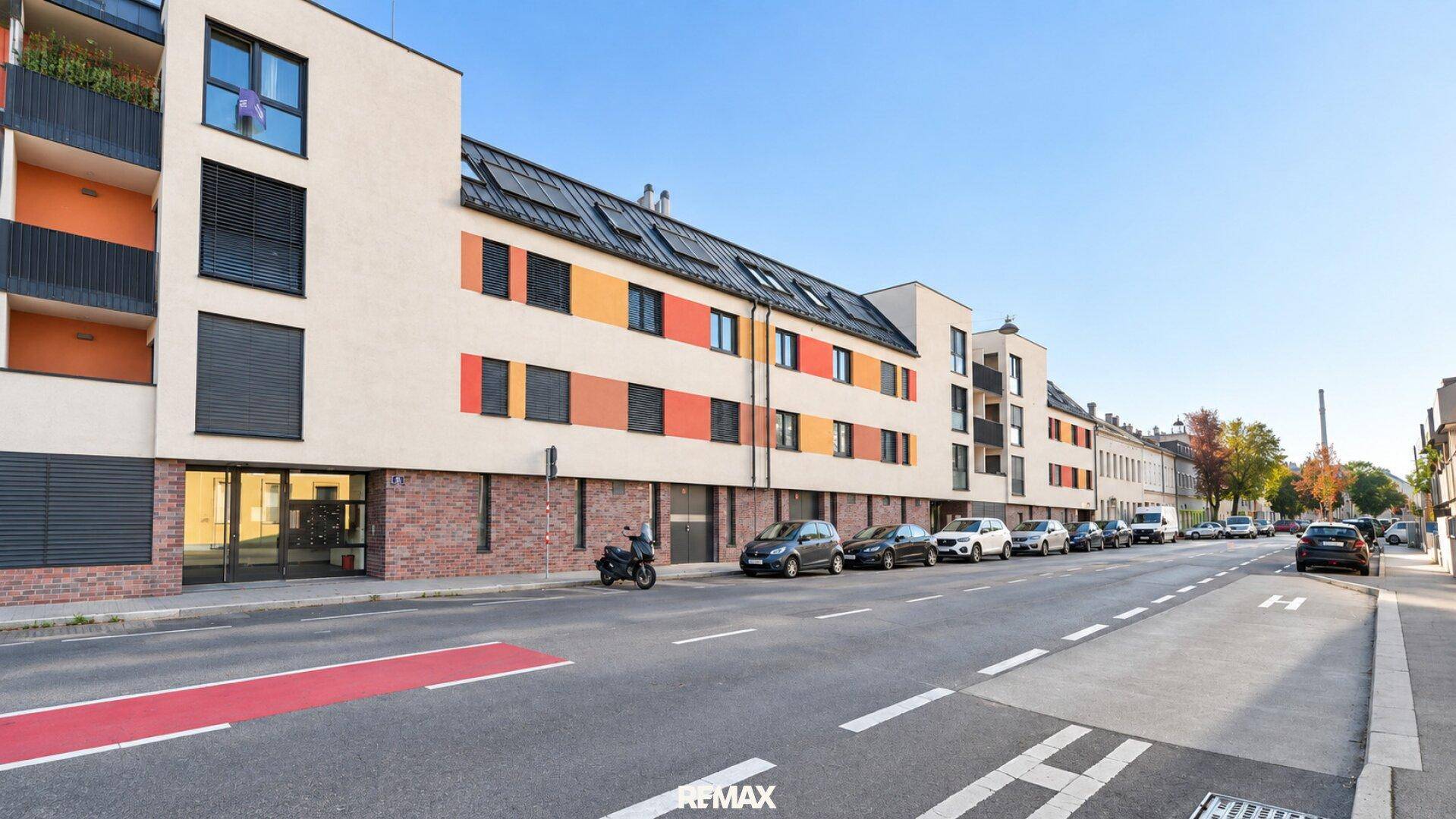 Ansicht der modernen Wohnanlage von der Straße mit farbigen Fassadenelementen.