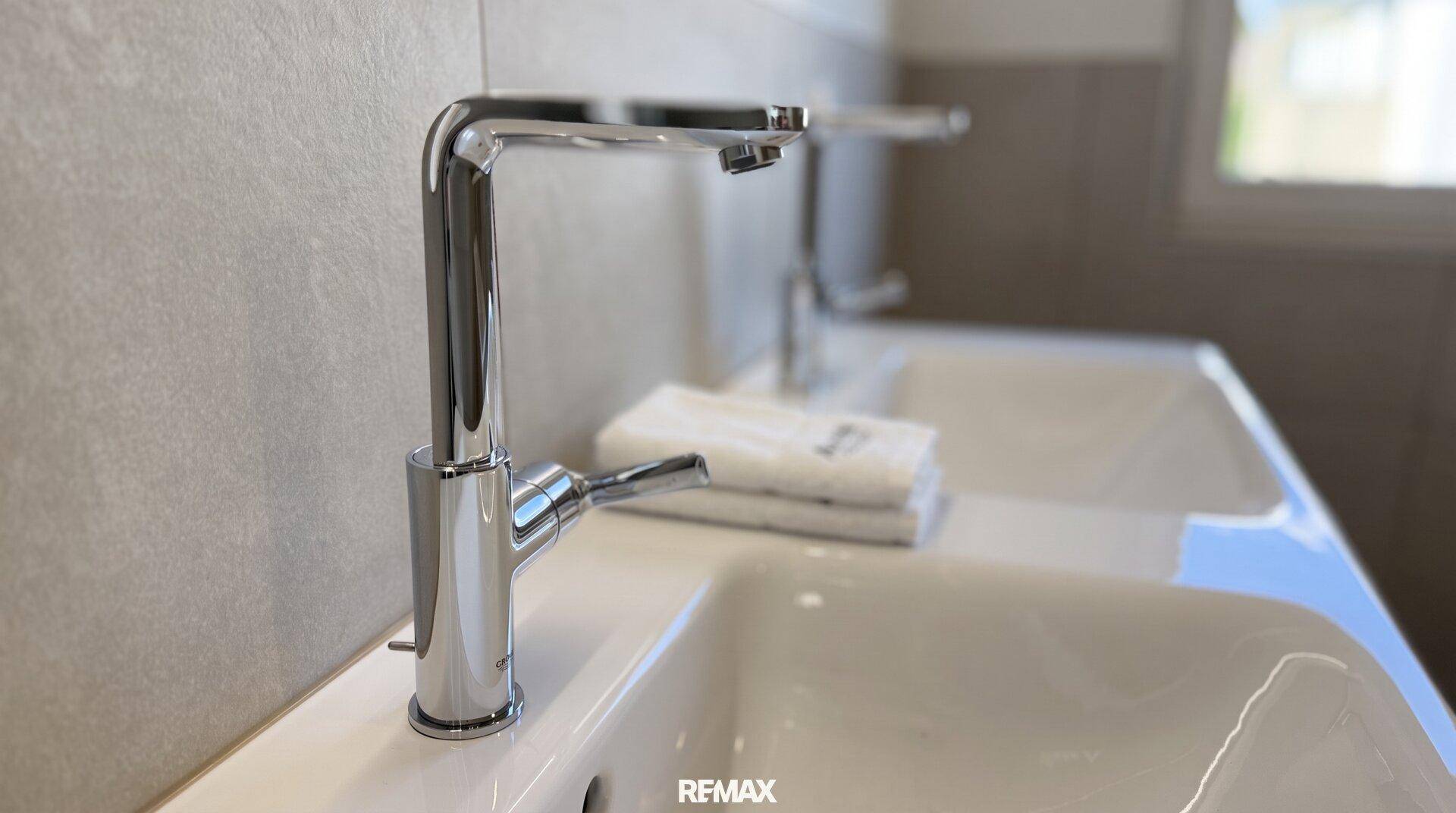 Detailaufnahme eines modernen Doppelwaschbeckens mit eleganten Armaturen im Badezimmer.