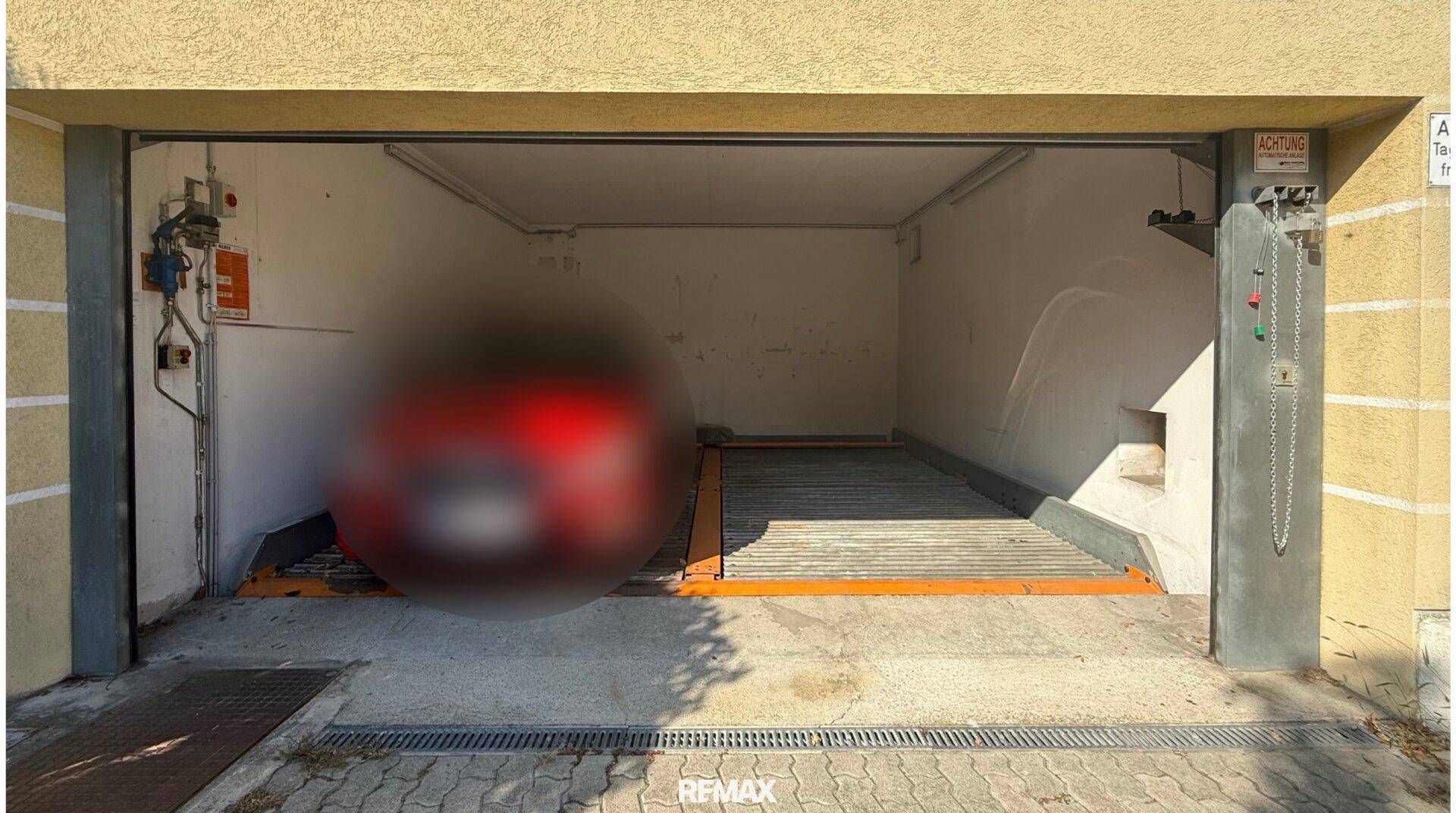 Einfahrt zu einer Tiefgarage mit automatischem Parksystem und Hebebühne für Fahrzeuge.