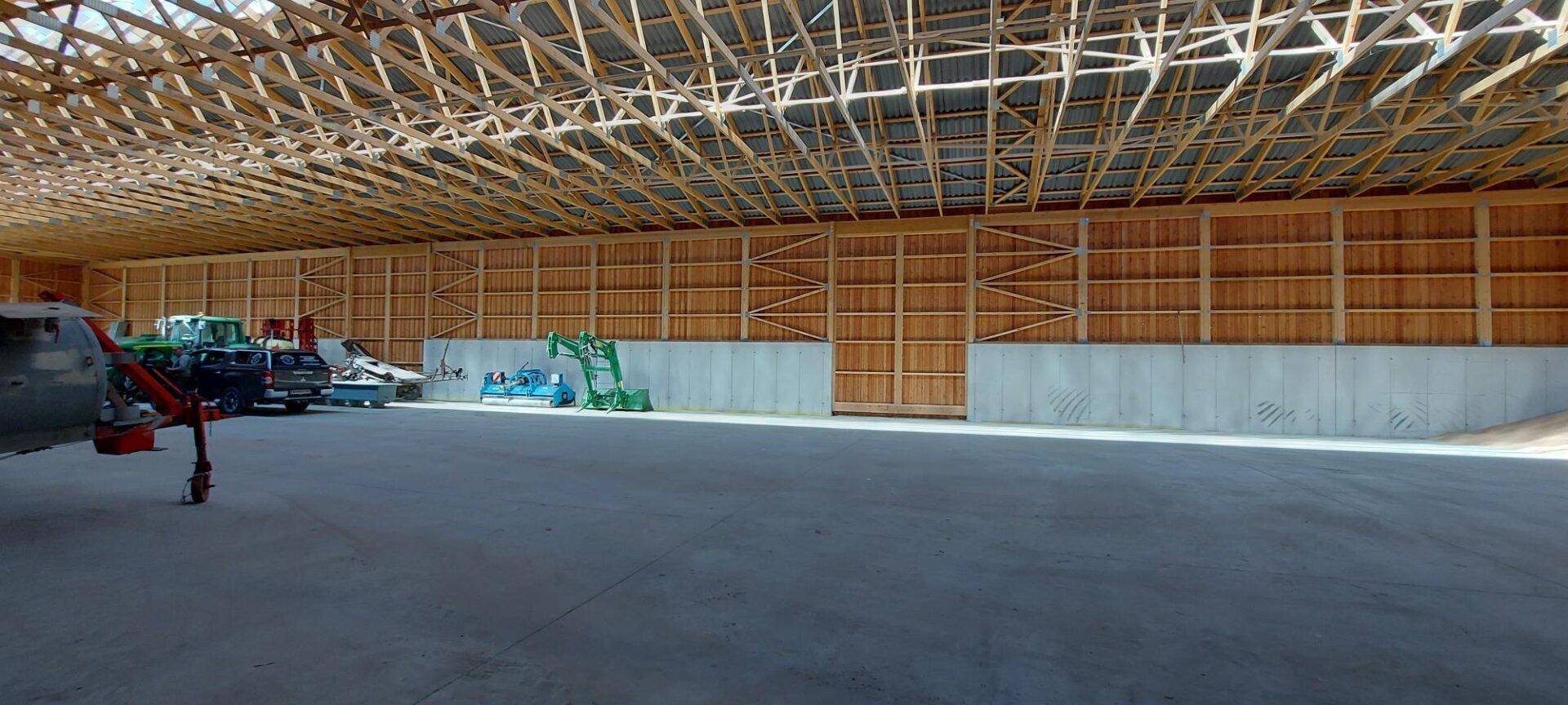Weitläufiger Innenraum der Lagerhalle mit sichtbarer Holzkonstruktion und viel Tageslicht.