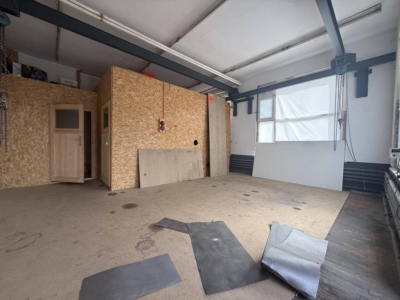 Funktionaler Raum mit OSB-Plattenwänden und sichtbaren Metallträgern, ideal als Abstellraum.