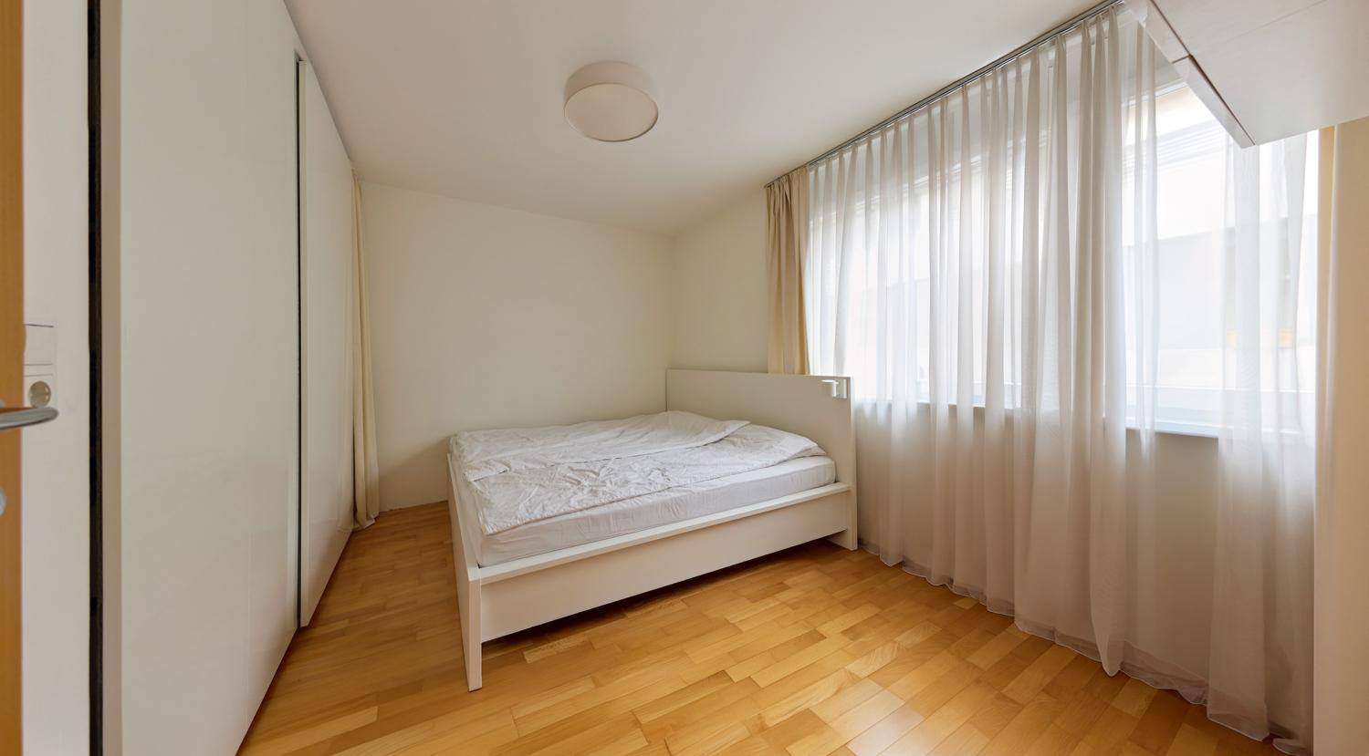 Schlafzimmer mit Doppelbett, Einbauschränken und hellem Holzboden.