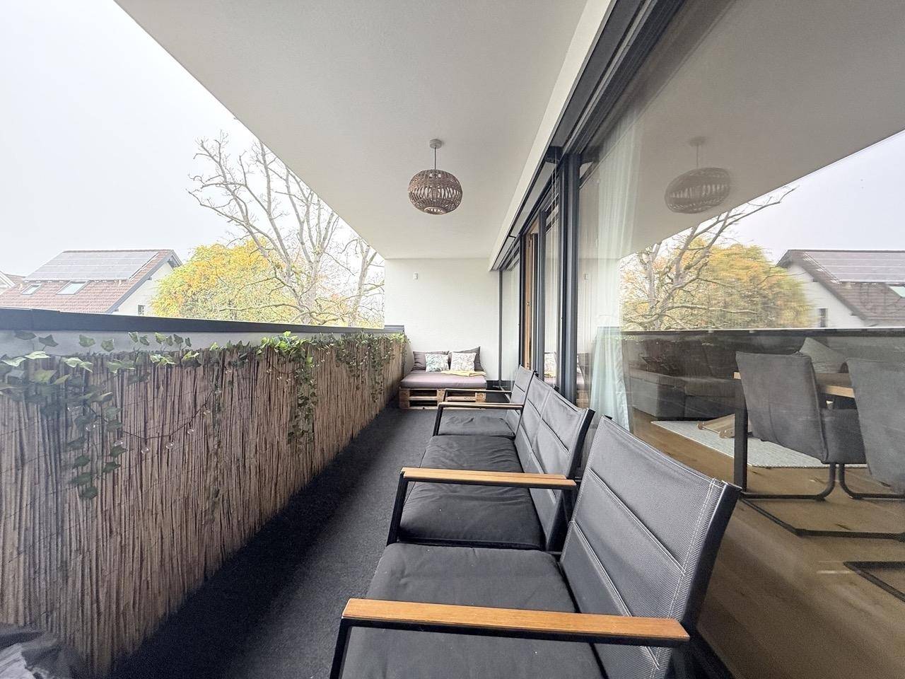 Geräumiger Balkon mit Sitzmöglichkeiten, Sichtschutz und Blick auf die Umgebung.
