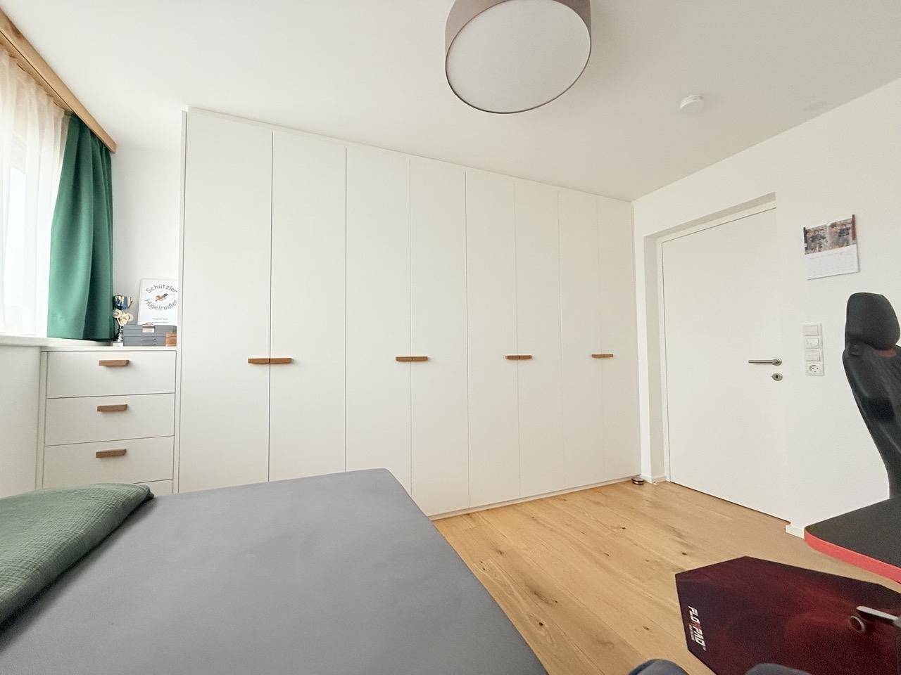 Schlafzimmer mit Einbauschränken, Holzboden und hellem Ambiente.