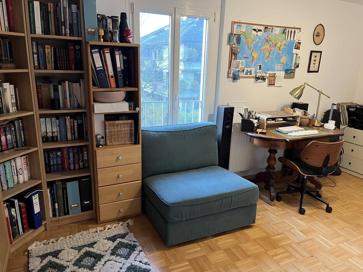 Arbeitszimmer mit Bücherregal, Schreibtisch und Sessel, ideal für Home-Office.