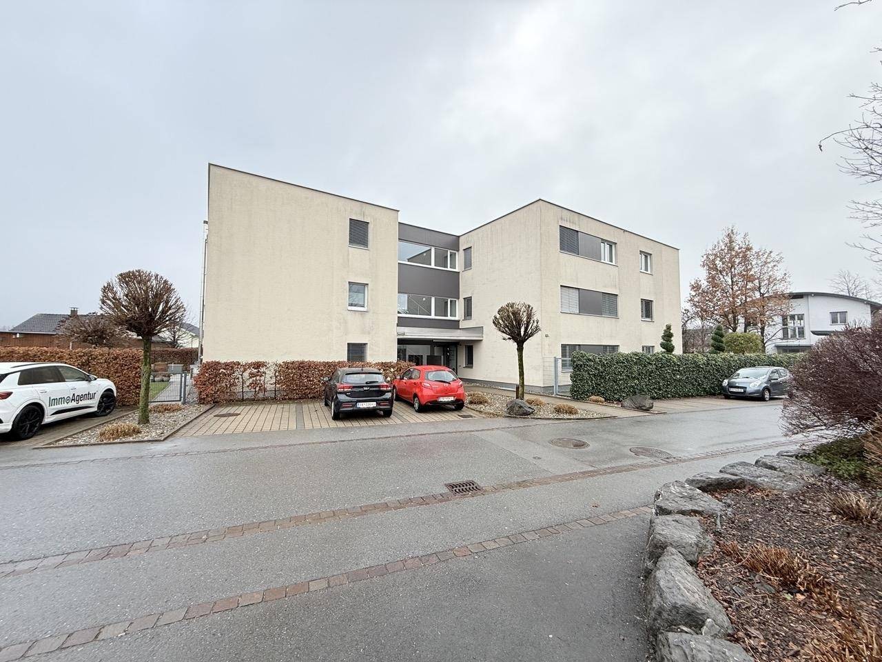 Moderne Wohnanlage mit gepflegter Außenfassade und Parkplätzen.