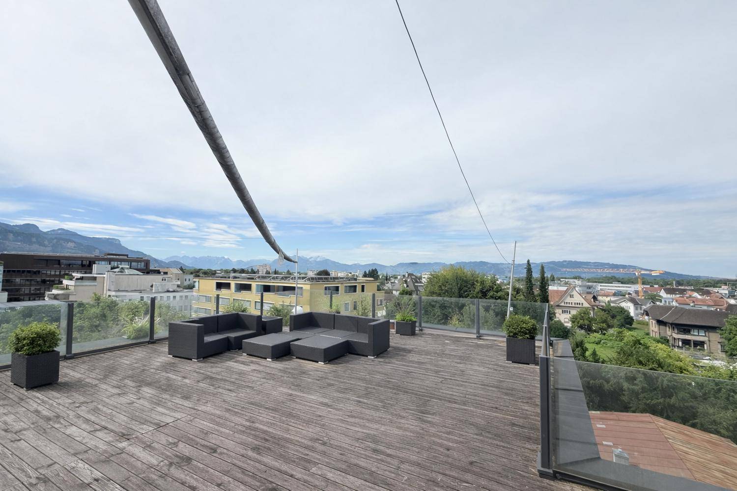 Weitläufige Dachterrasse mit modernen Loungemöbeln und beeindruckendem Panoramablick.