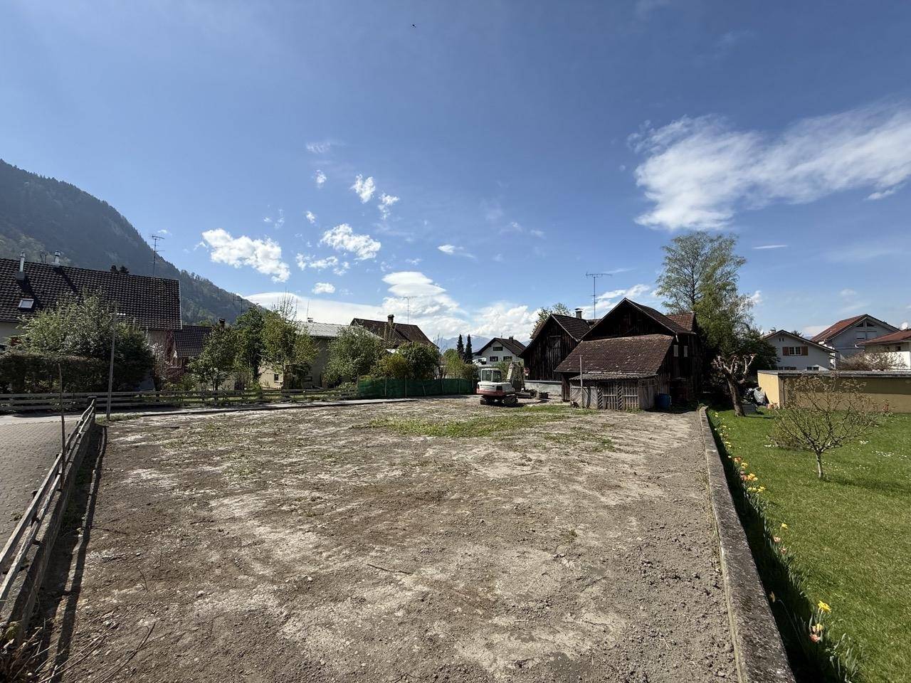 Weitläufiges Grundstück mit Blick auf die umliegende Bebauung und die Bergkulisse.