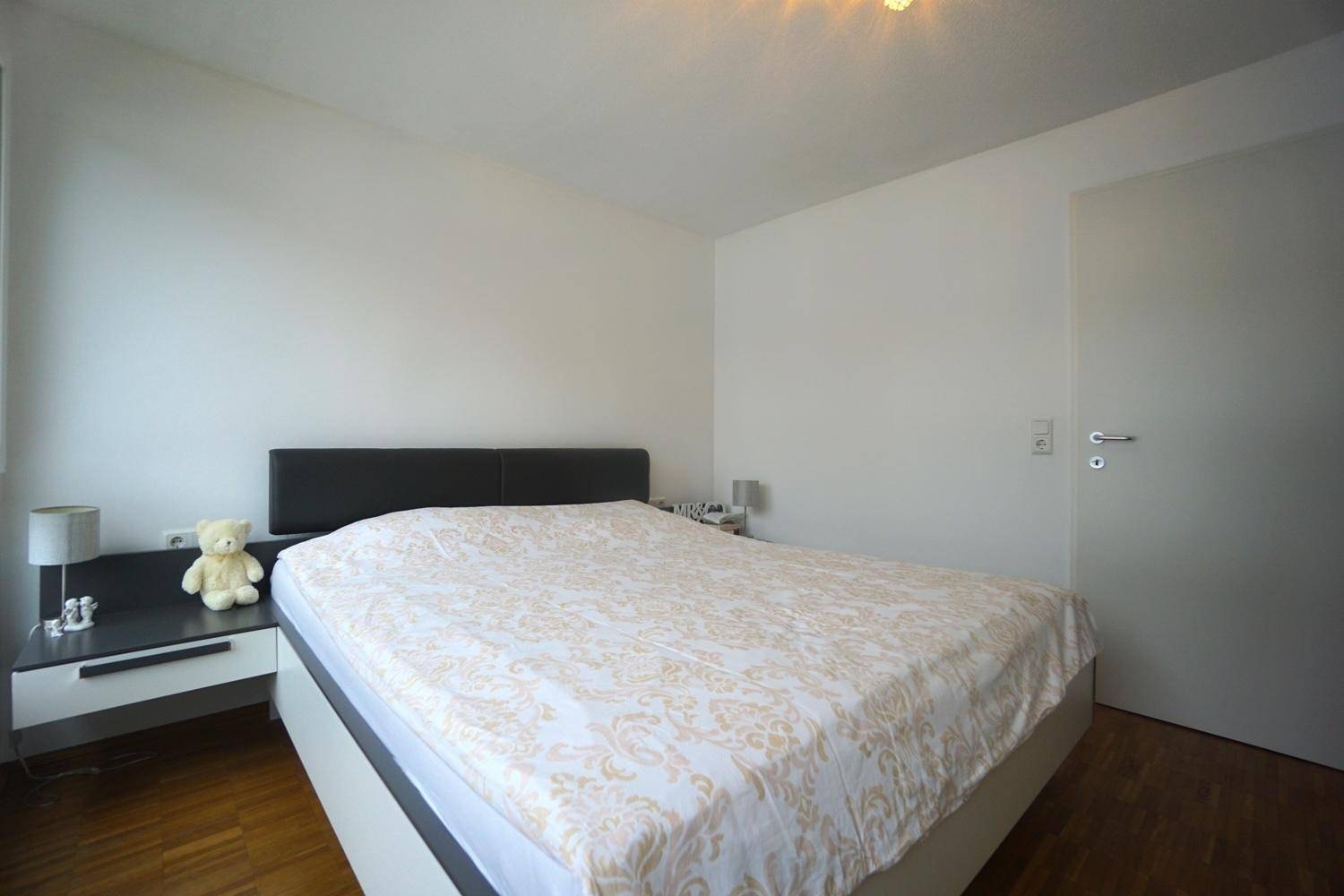 Schlafzimmer mit komfortablem Doppelbett und schlichten Nachttischen, ideal für Ruhe und Erholung.