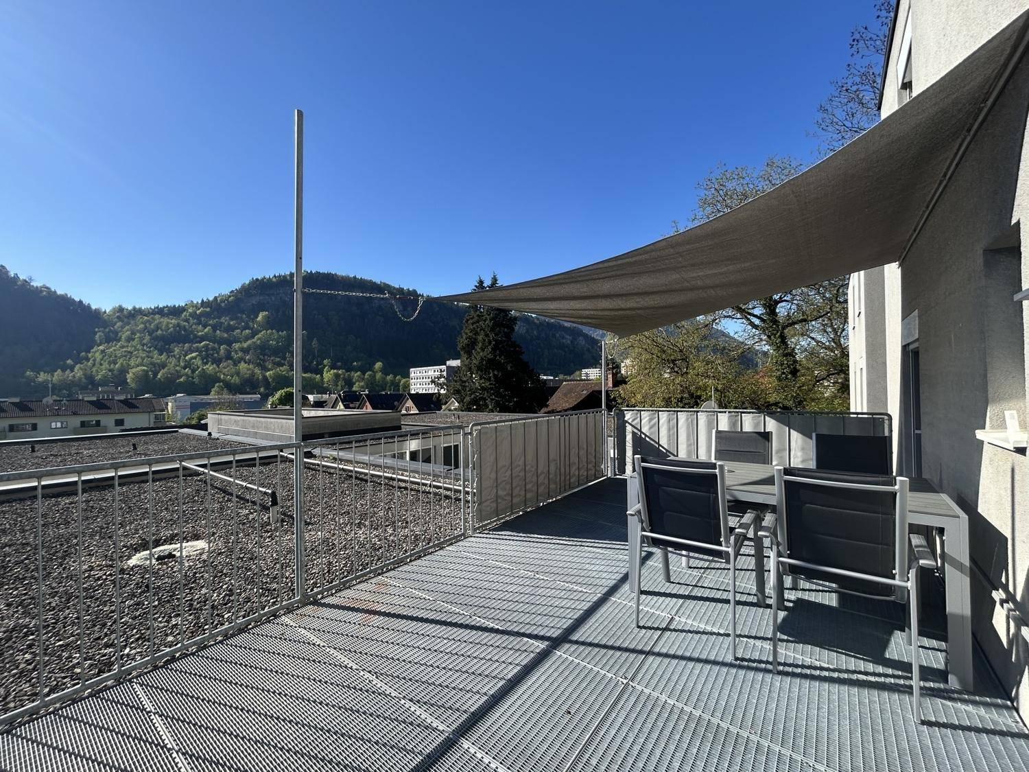 Weitläufige Dachterrasse mit Sitzgelegenheiten und Panoramablick auf die Stadt und die umliegende Natur.