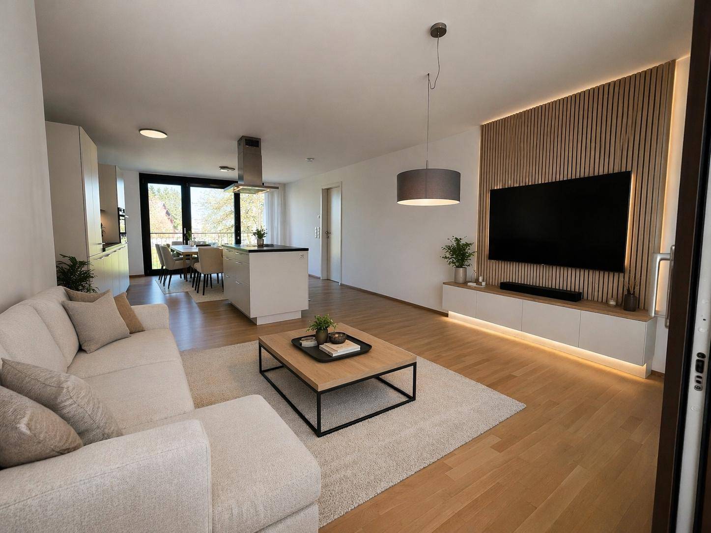 Moderner offener Wohnbereich mit Sofa, Holzboden und stilvoller TV-Wandgestaltung.