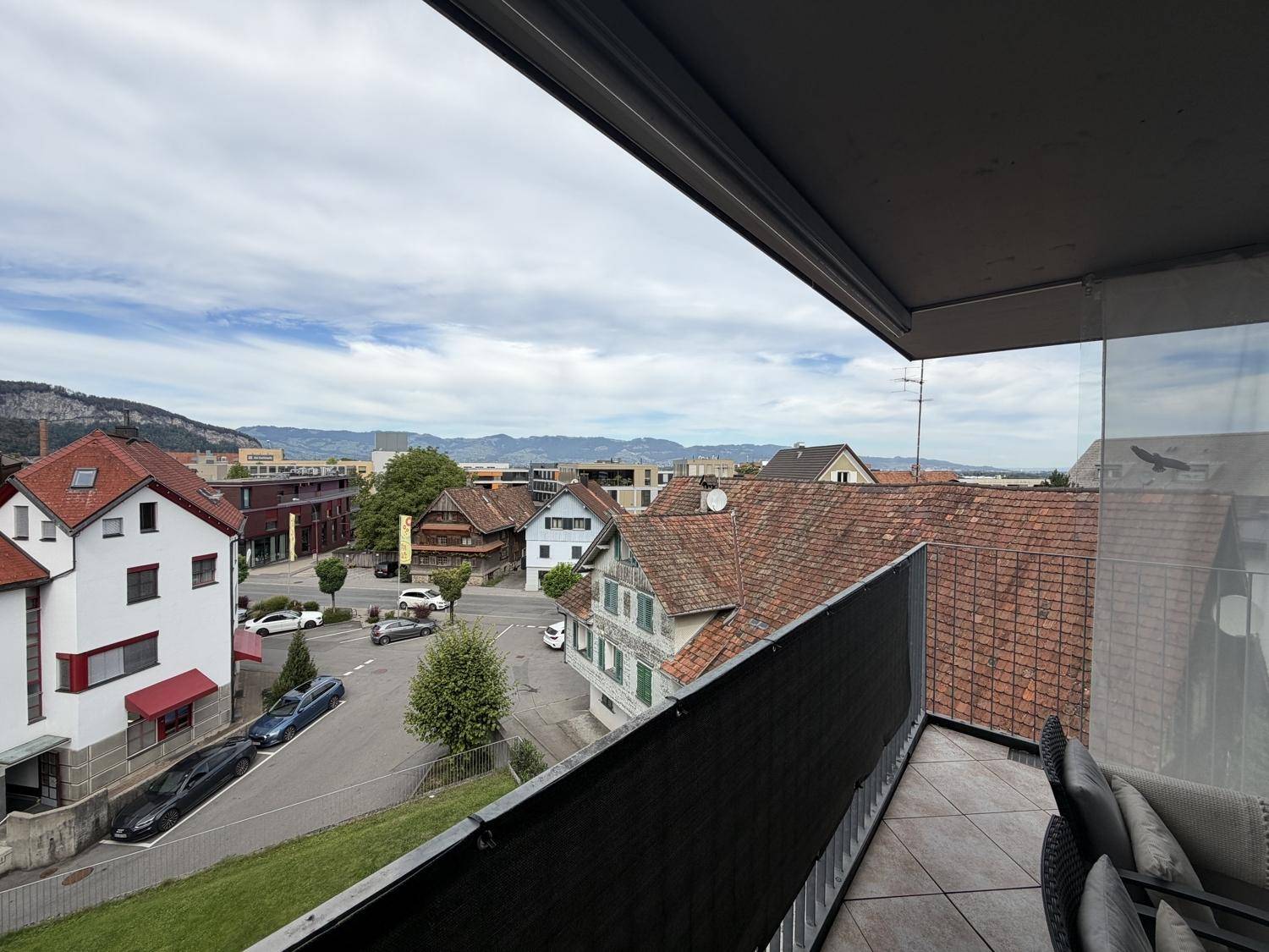 Geräumiger Balkon mit Sitzgelegenheiten und einem weiten Panoramablick über die Nachbarschaft und Berge.