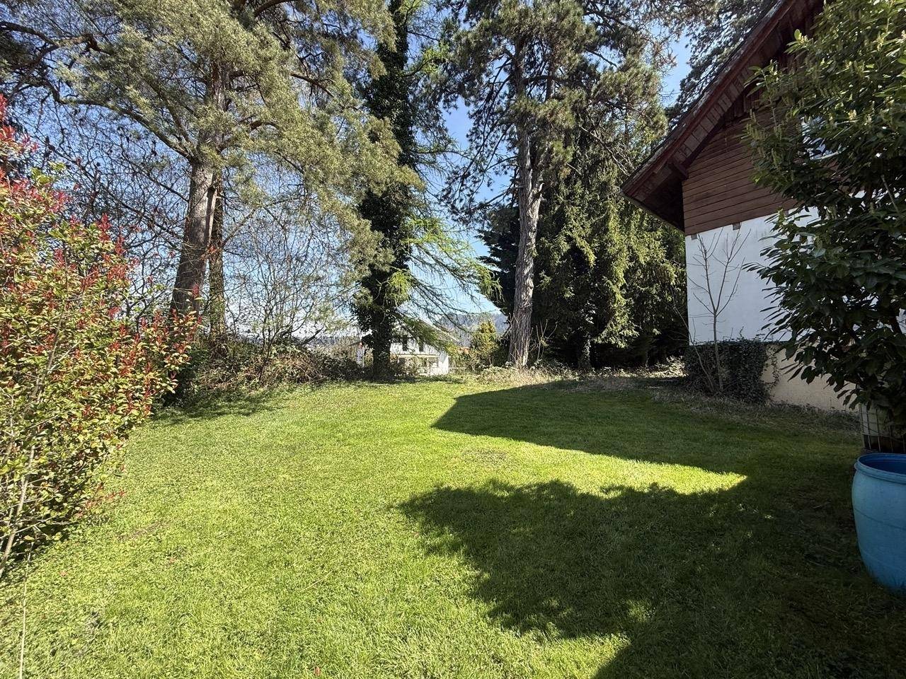 Weitläufige Rasenfläche im Garten mit Blick auf die umliegende Berglandschaft.