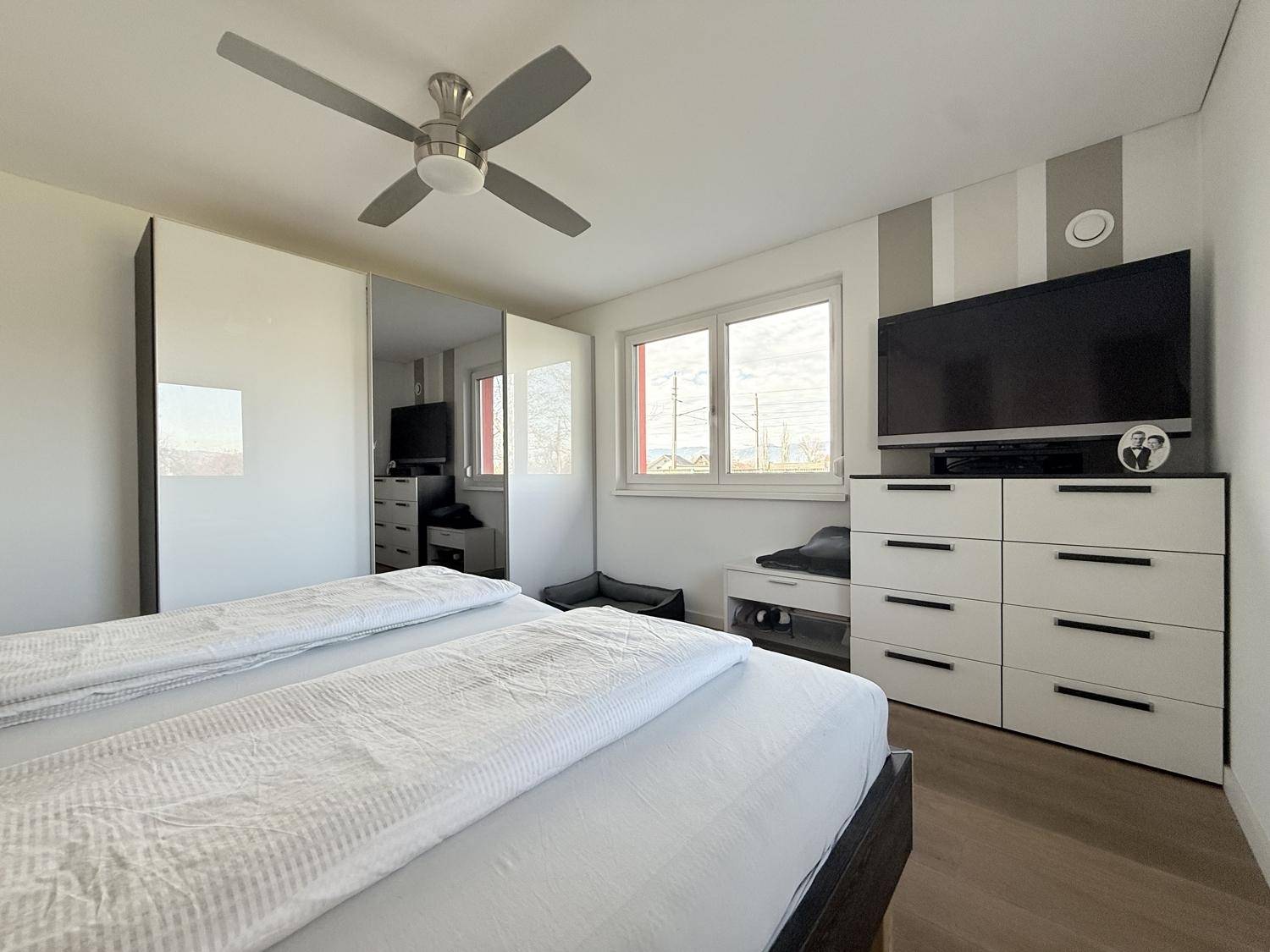 Schlafzimmer mit Einbauschränken, Doppelbett und hellen Wänden.
