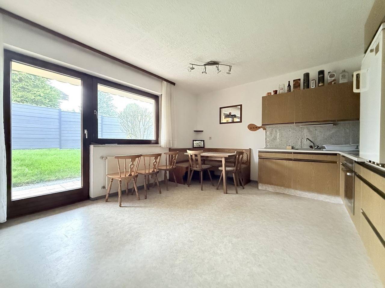 Helle Küche mit Essbereich und direktem Zugang zum Garten, ideal für Mahlzeiten im Freien.