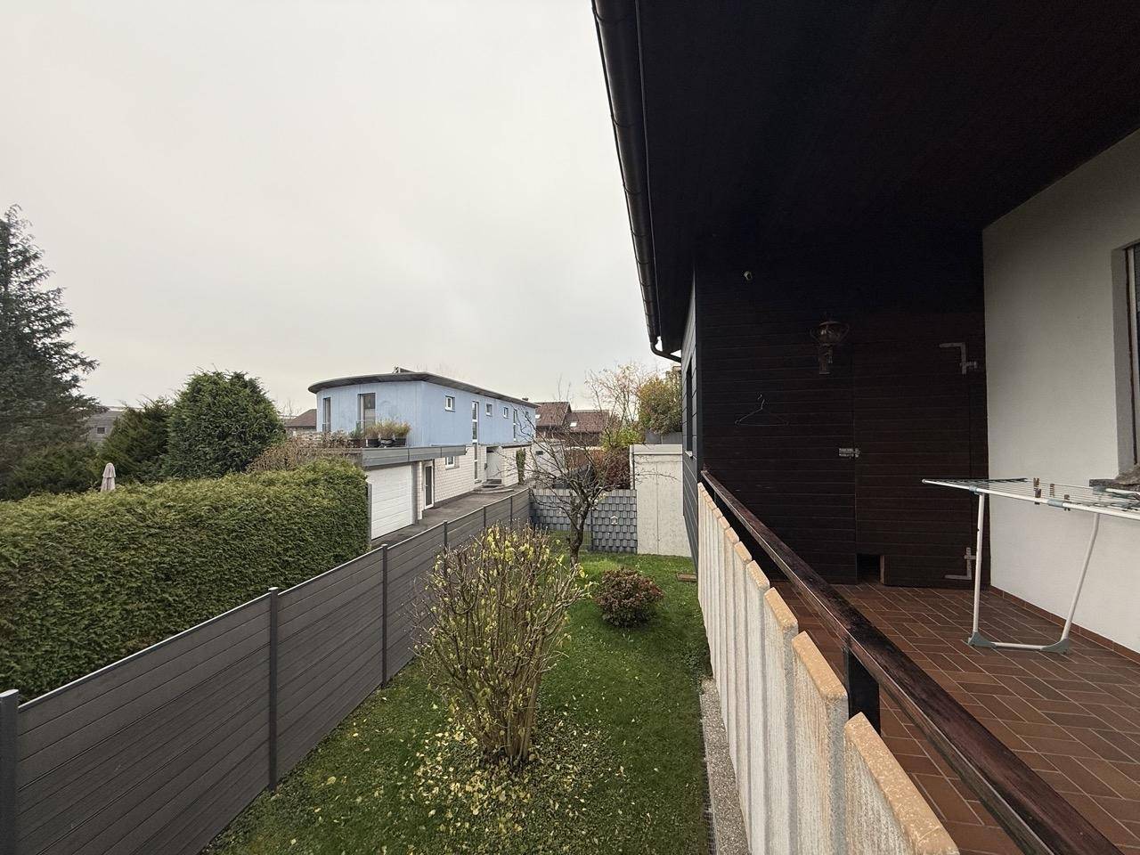 Balkon mit Blick auf den Garten und die umliegenden Häuser, ausgestattet mit einem Wäscheständer.