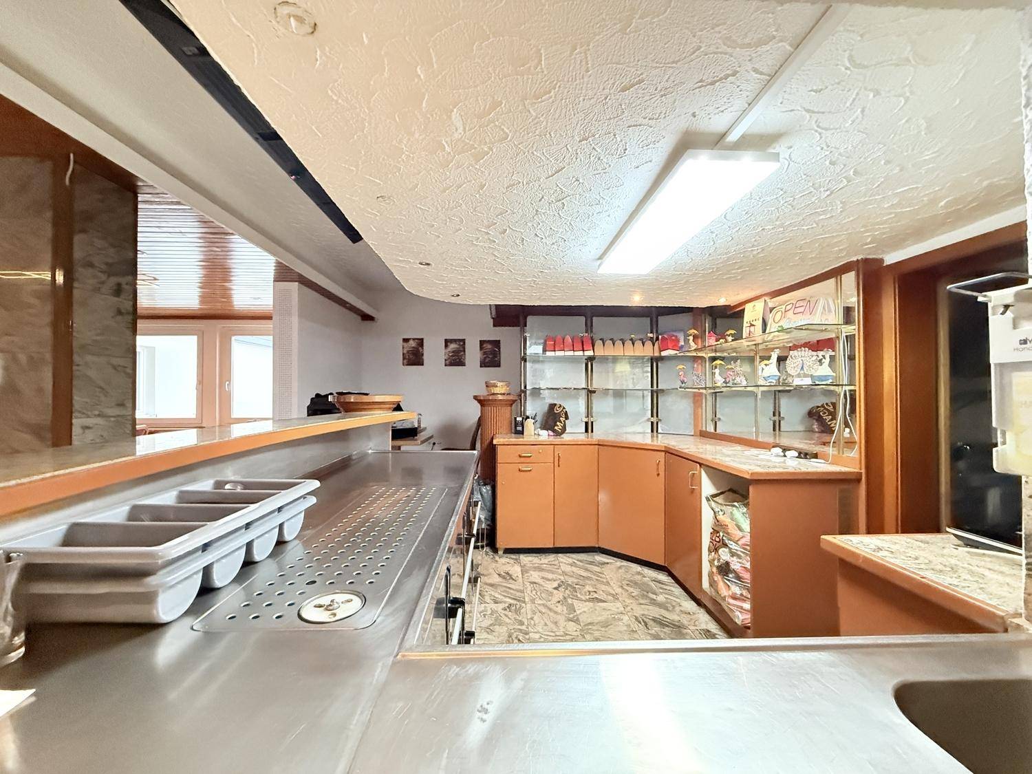 Thekenservicebereich mit Edelstahlflächen und Regalen für Getränke und Snacks.