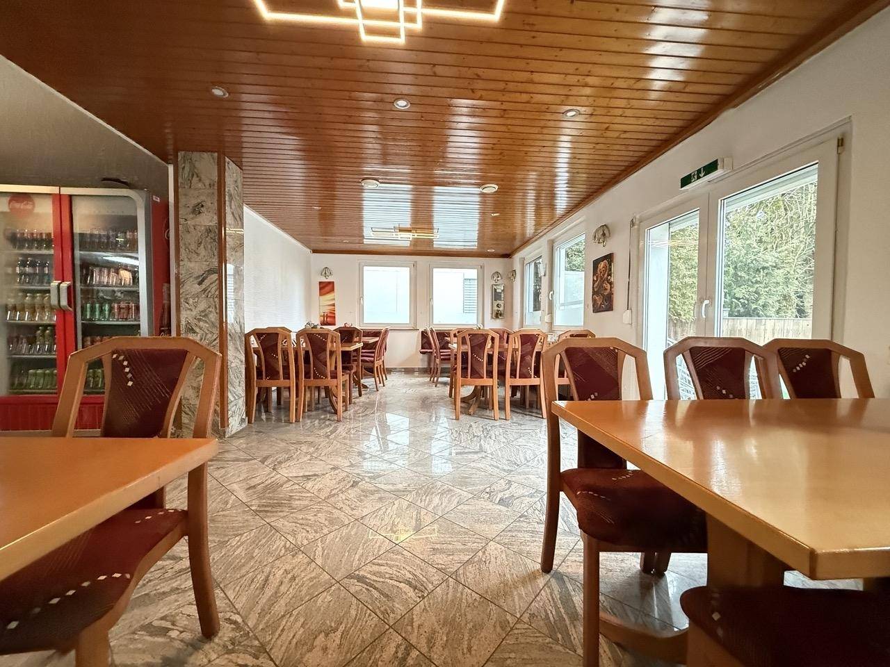 Geräumiger Essbereich mit Holztäfelung an der Decke und gemusterten Fliesenboden.