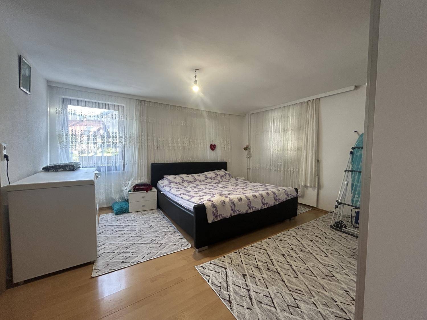 Geräumiges Schlafzimmer mit Doppelbett, Teppich und Fenster, bietet viel Platz und natürliches Licht.