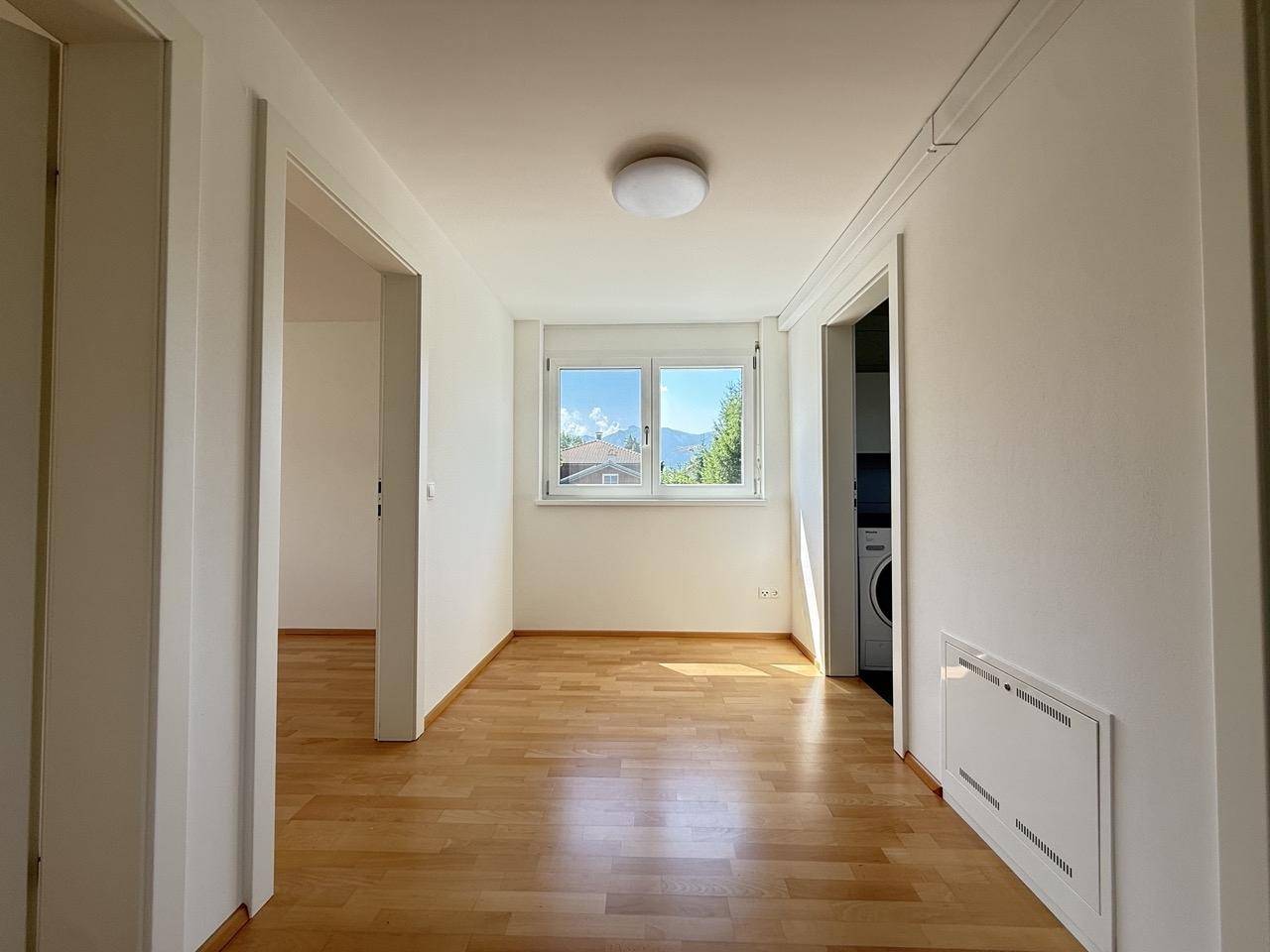 Heller Flurbereich mit Holzfußboden und einem Fenster, das den Raum mit Tageslicht füllt.
