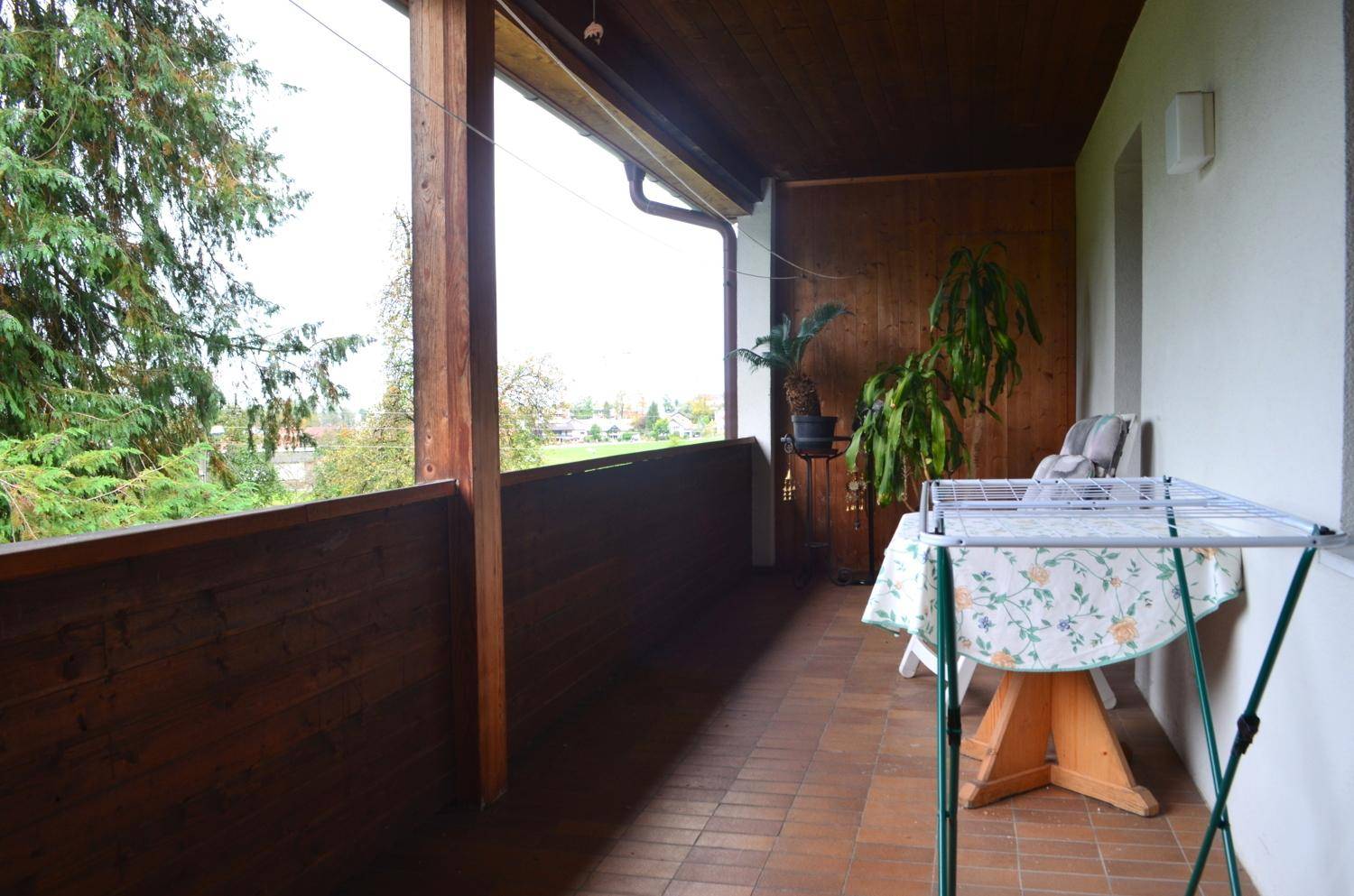 Geräumiger Balkon mit Holzverkleidung und weitem Blick über die Landschaft.