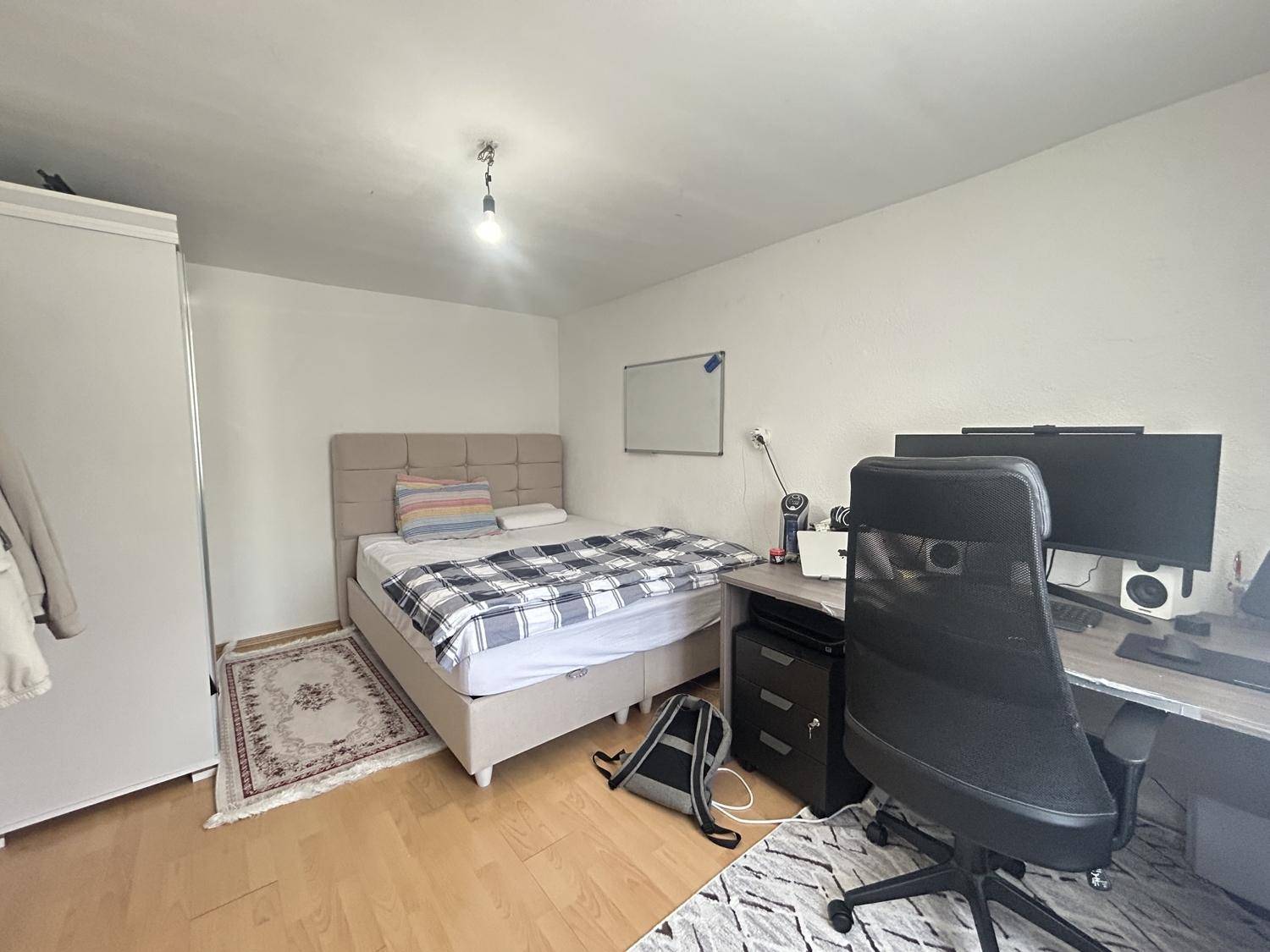 Schlafzimmer mit Bett, Schreibtisch und Bürostuhl, ideal als Gästezimmer oder Arbeitsbereich.