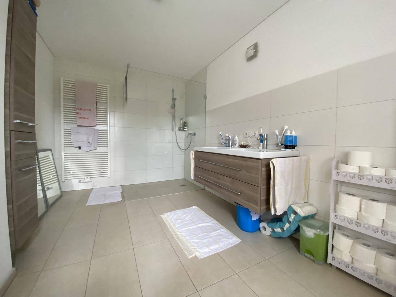 Modernes Badezimmer mit begehbarer Dusche, Einzelwaschbecken und Handtuchheizkörper.