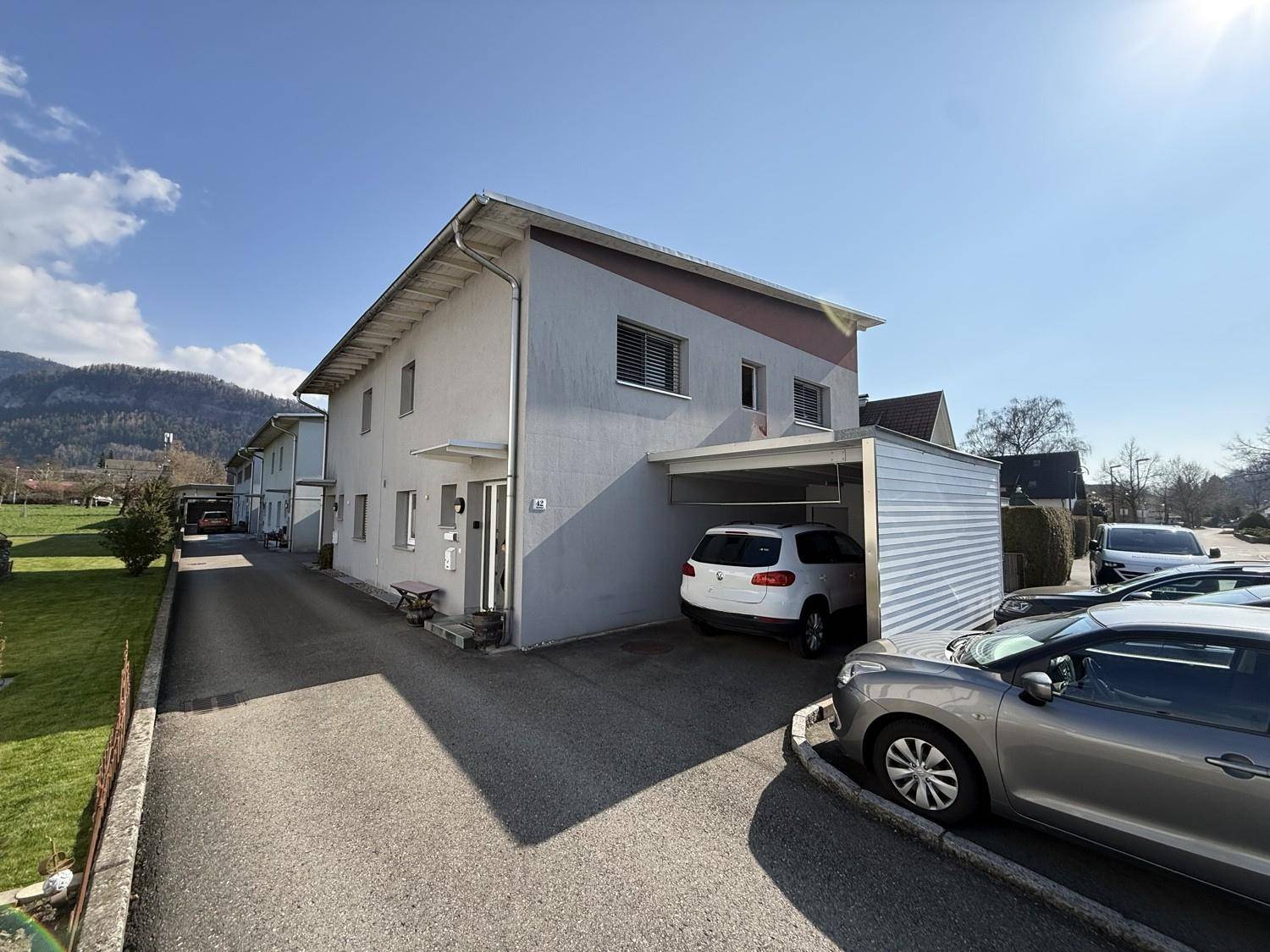 Seitenansicht des Wohnhauses mit Carport, Einfahrt und weiteren Parkmöglichkeiten.