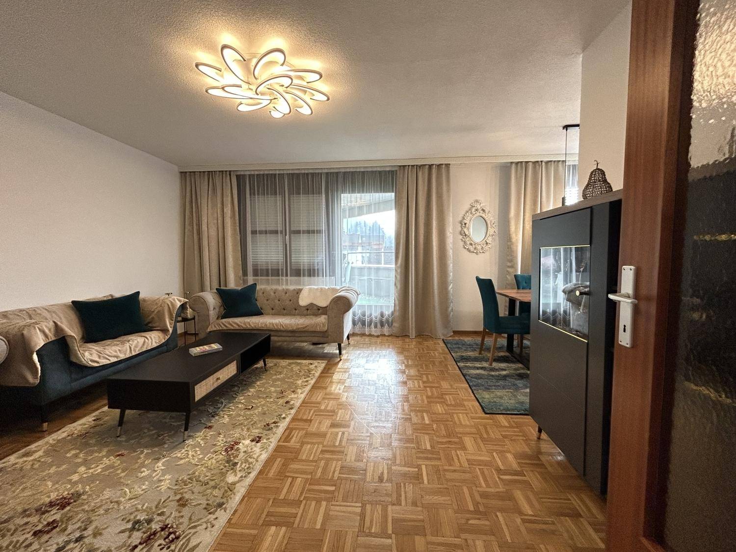 Gemütlicher Wohnbereich mit Parkettboden, zwei Sofas und Zugang zum Essbereich.