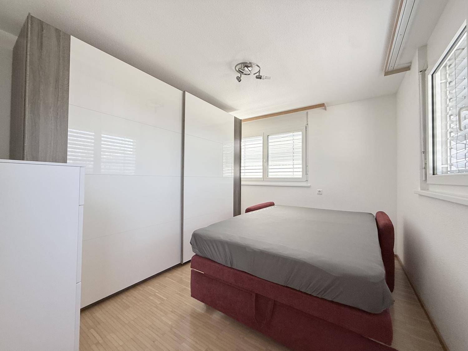 Gemütliches Schlafzimmer mit Parkettboden, Schlafsofa und großem Kleiderschrank.