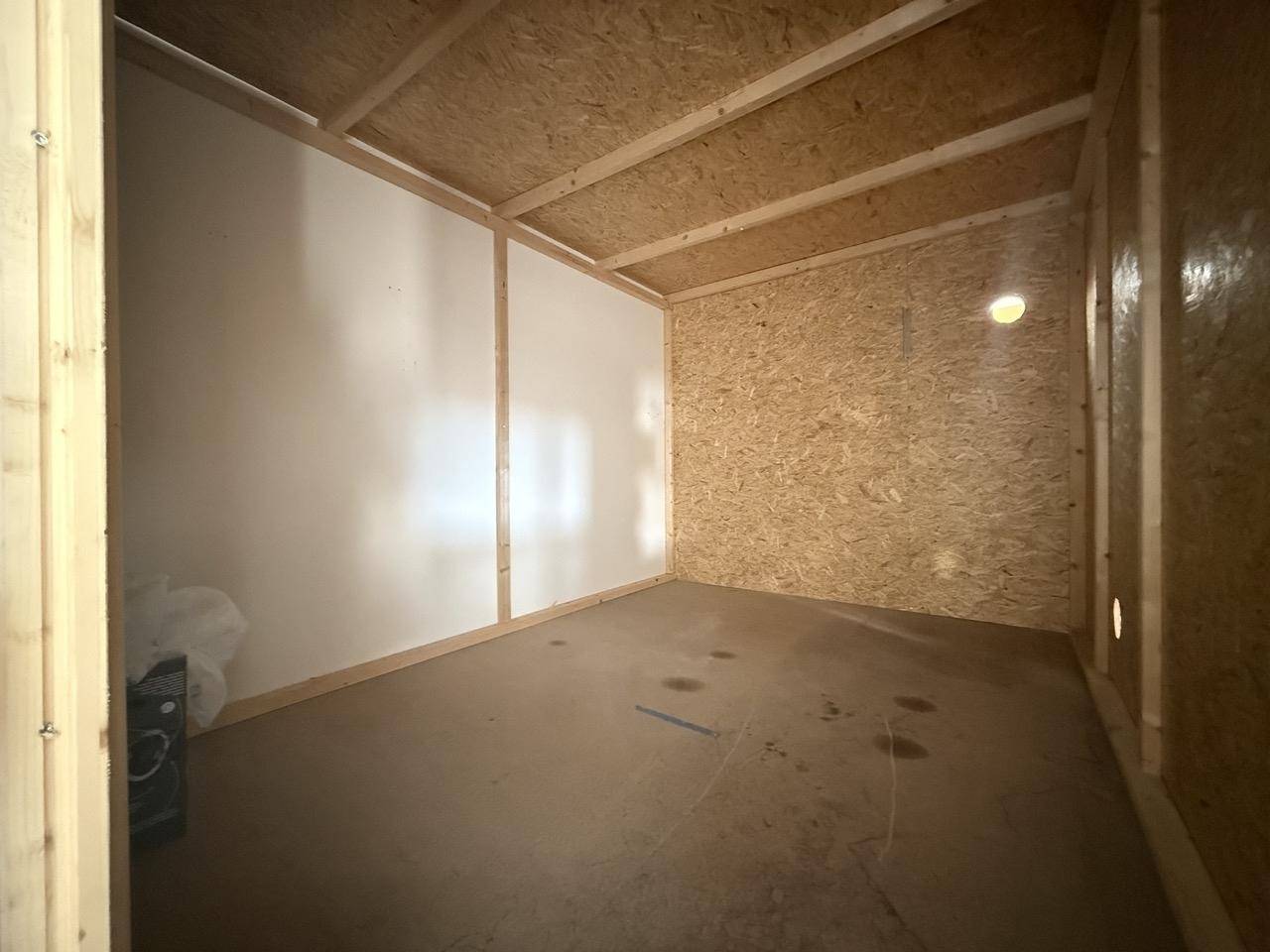 Kleiner, einfacher Abstellraum mit OSB-Platten an Wänden und Decke.
