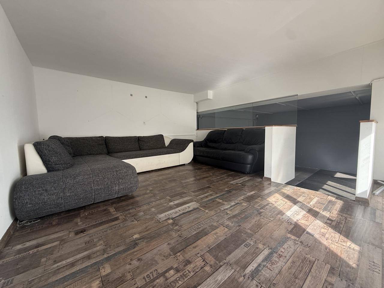 Gemütlicher Wohnbereich auf einer Empore mit großem Ecksofa und einzigartigem Holzboden.