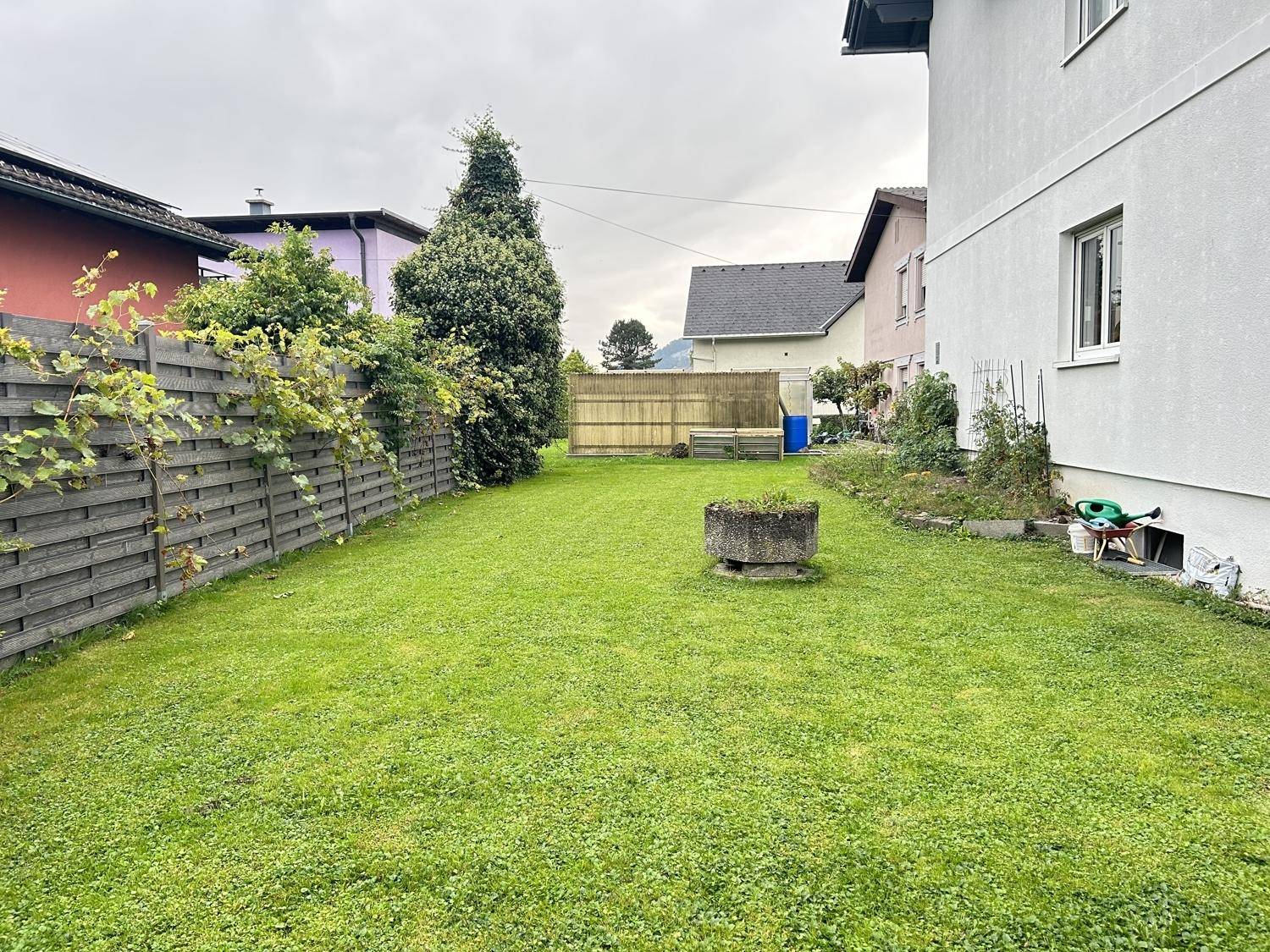Großer Garten mit gepflegtem Rasen und Holzzaun, bietet viel Platz für Freizeitaktivitäten im Freien.