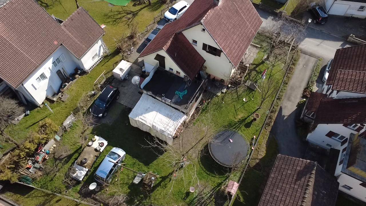 Luftaufnahme des Hauses mit Garten, Trampolin und umliegenden Gebäuden in einer Wohnsiedlung.