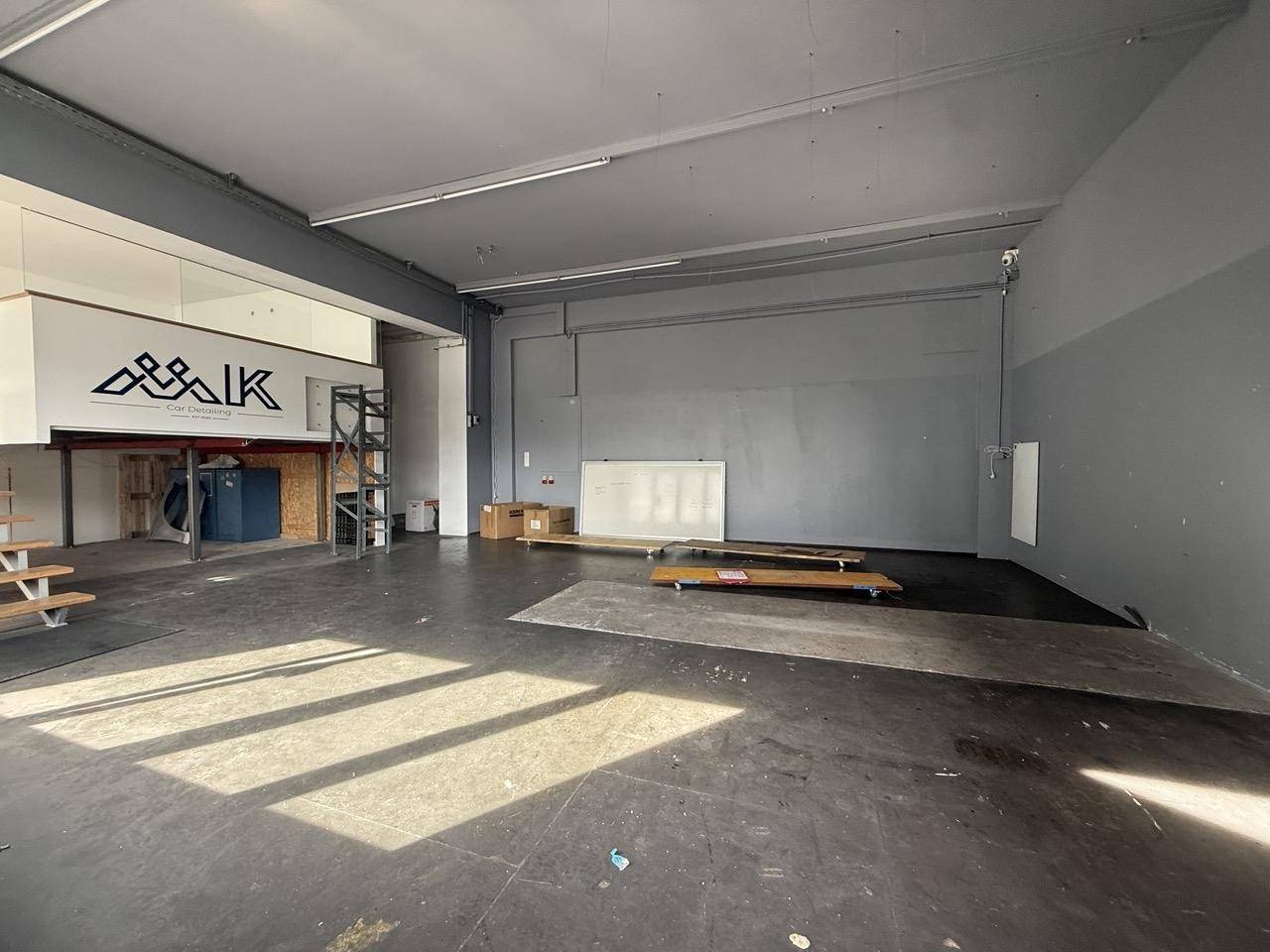 Großer, leerer Raum mit Betonboden und hohen Decken, ideal für Werkstatt oder Lager.