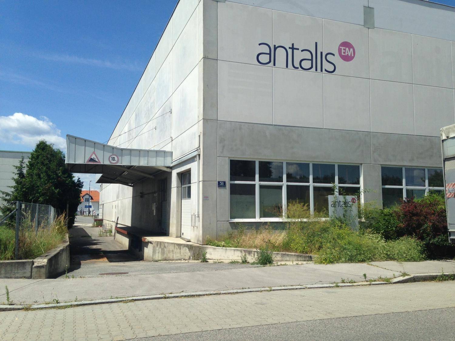 Industrielles Gebäude mit überdachtem Ladebereich und dem Firmenlogo "antalis" an der Fassade.