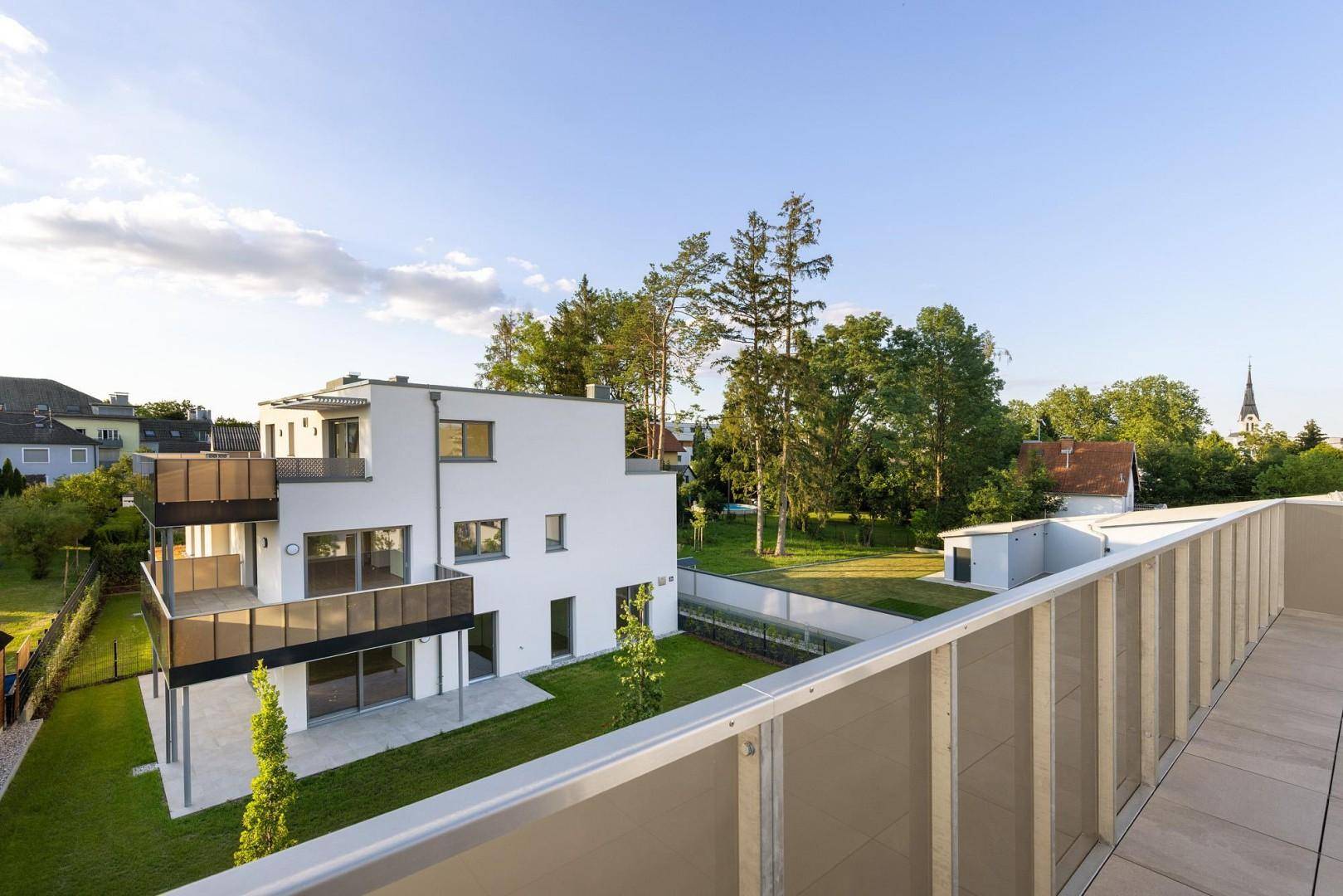 Panoramablick auf das moderne Wohngebäude mit umliegenden Gärten und der Nachbarschaft.