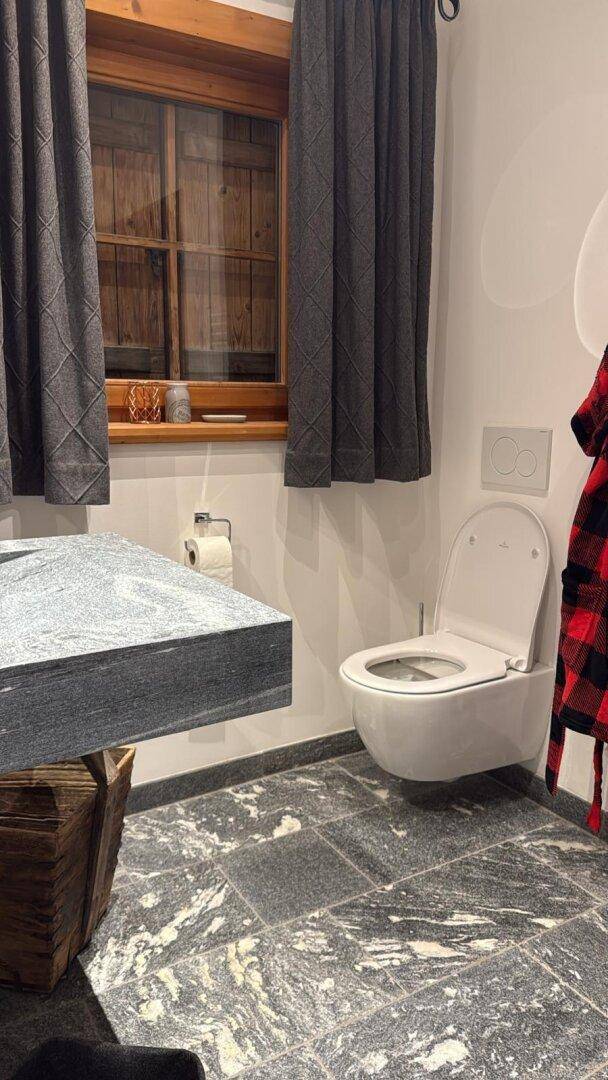 Modernes Gäste-WC mit schwebendem Granitwaschtisch und Wand-WC.